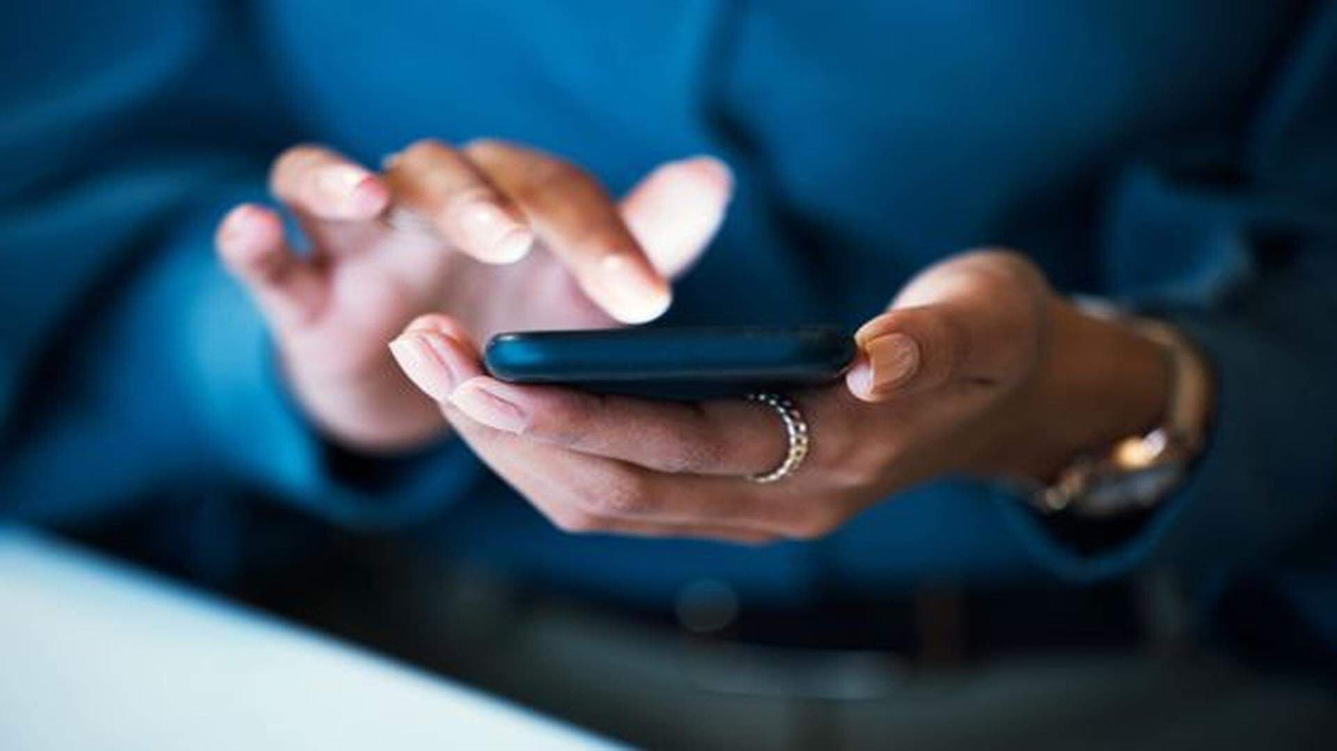 Händer från kvinna som håller i mobiltelefon