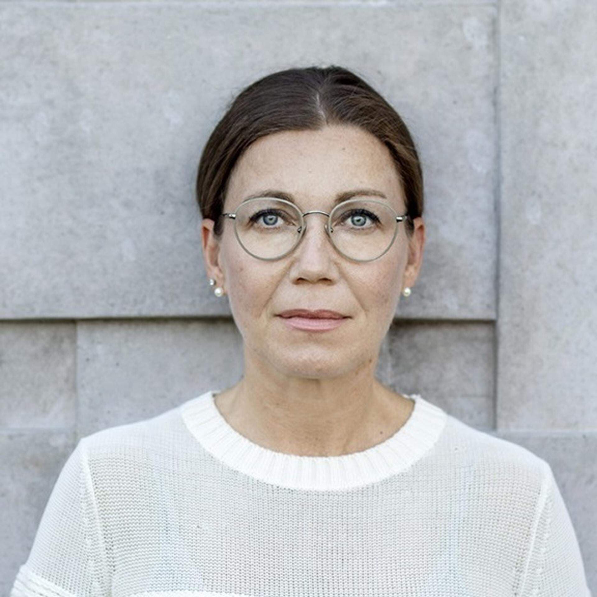 Tanja Rasmusson framför en betongvägg med kubisikt mönster