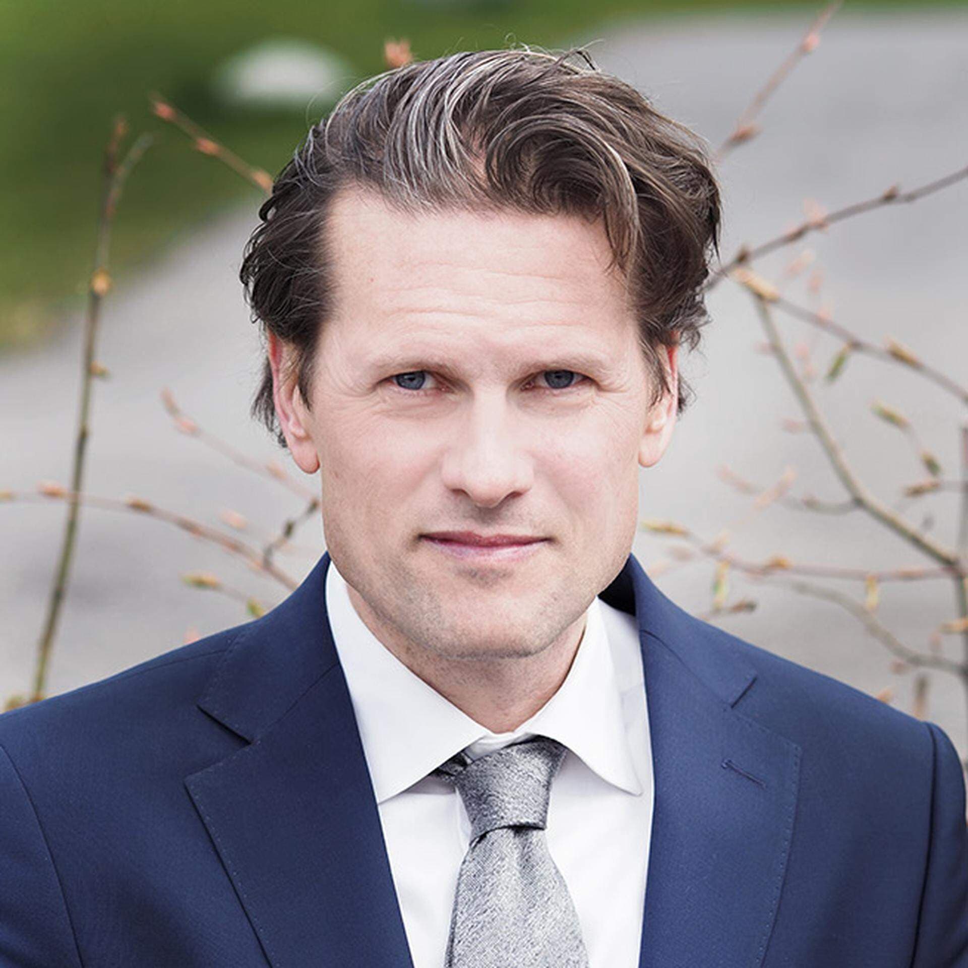 Mattias Svensson i blå kavaj, vit skjorta och grå slips