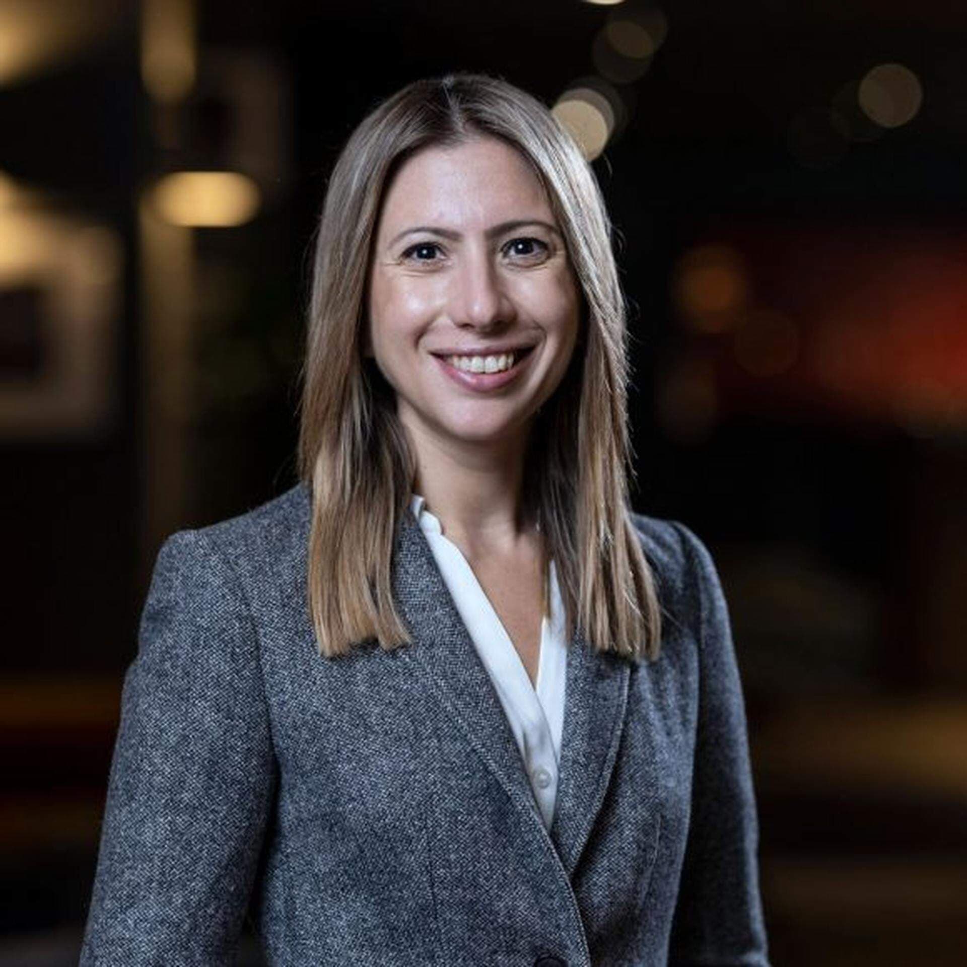 Ana iklädd vit skjorta och grå kavaj