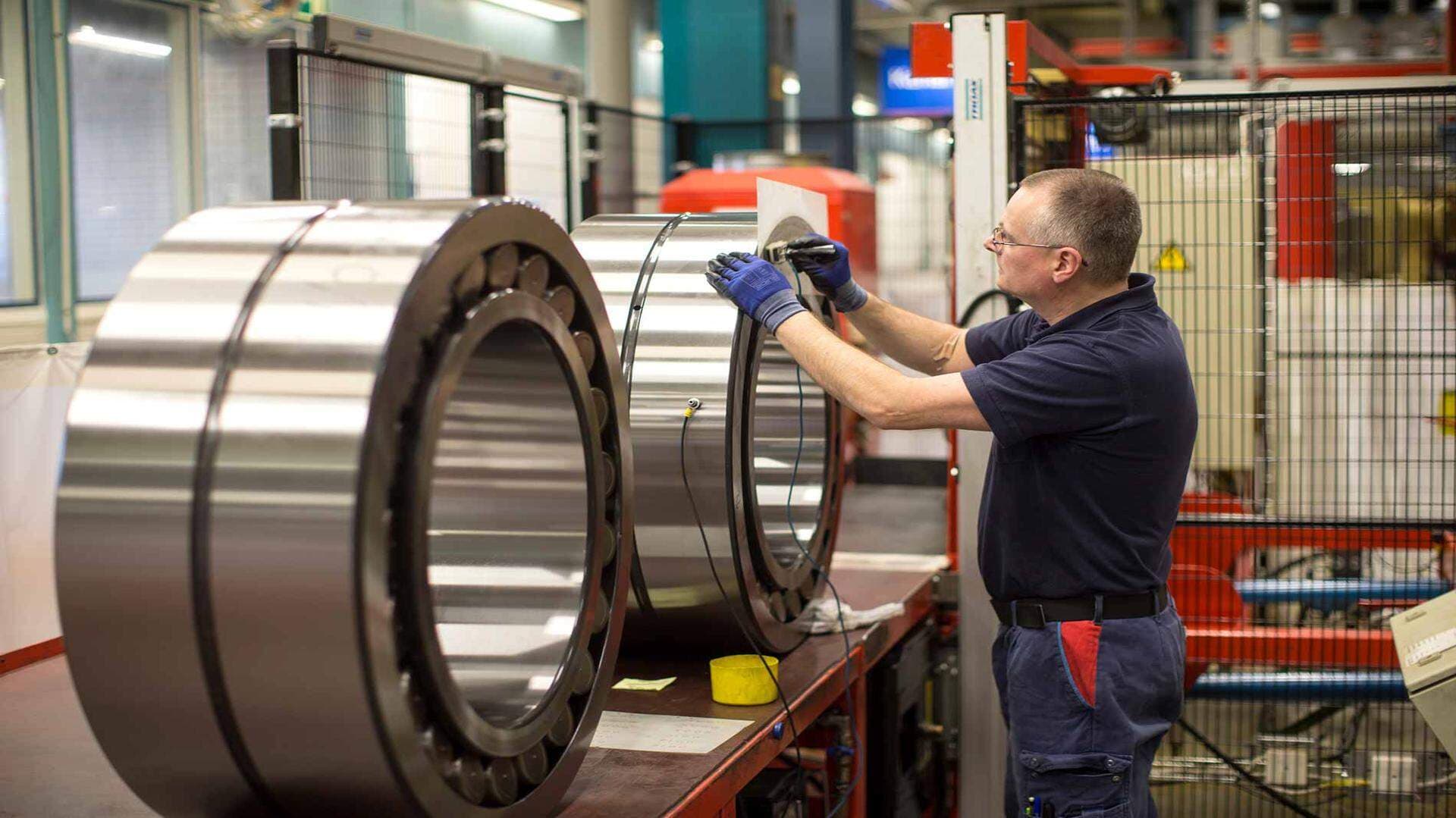 Man arbetar med ett kugghjul på ett industriföretag