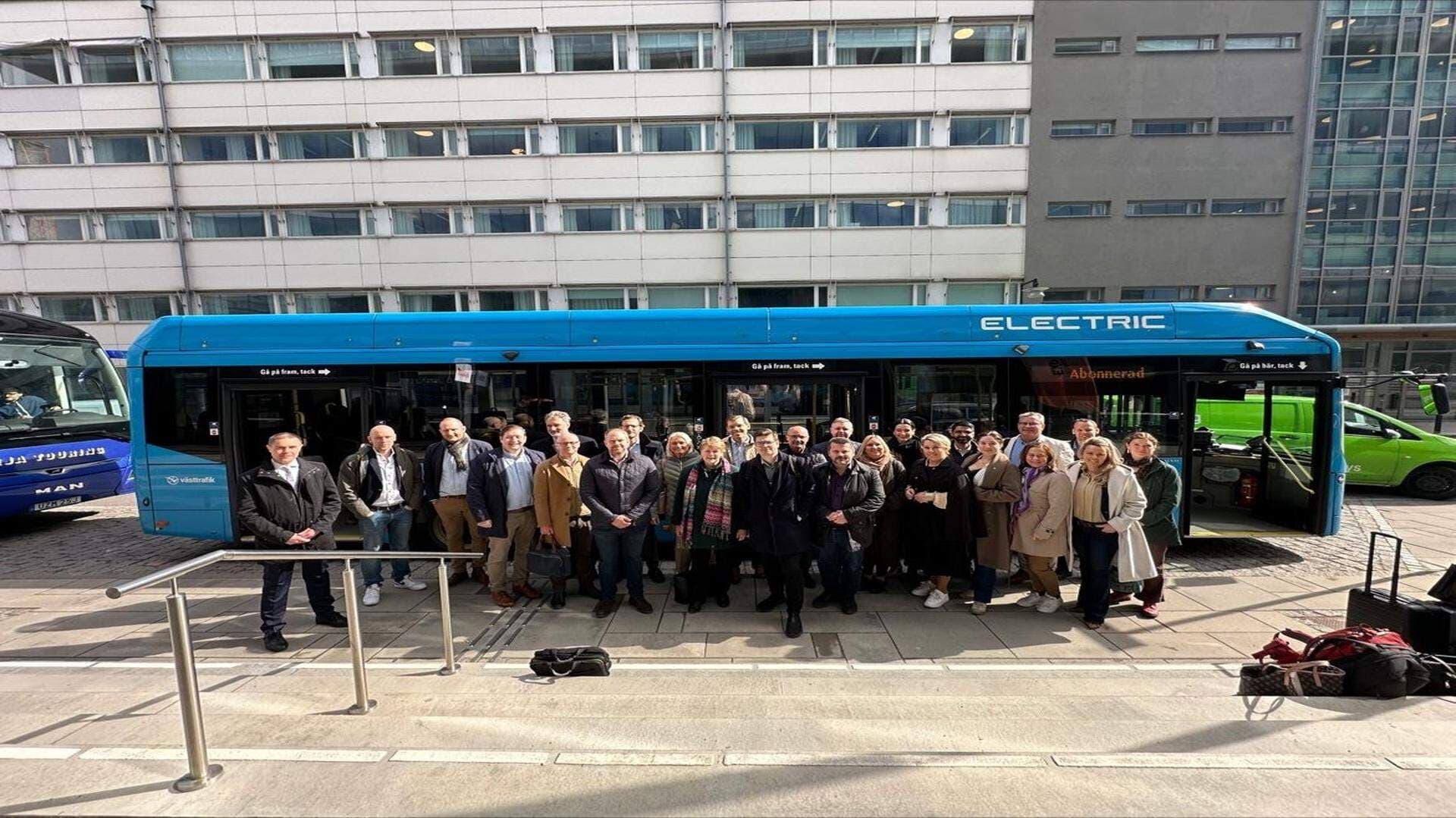 Riksdagsledamöter utanför buss gruppfoto