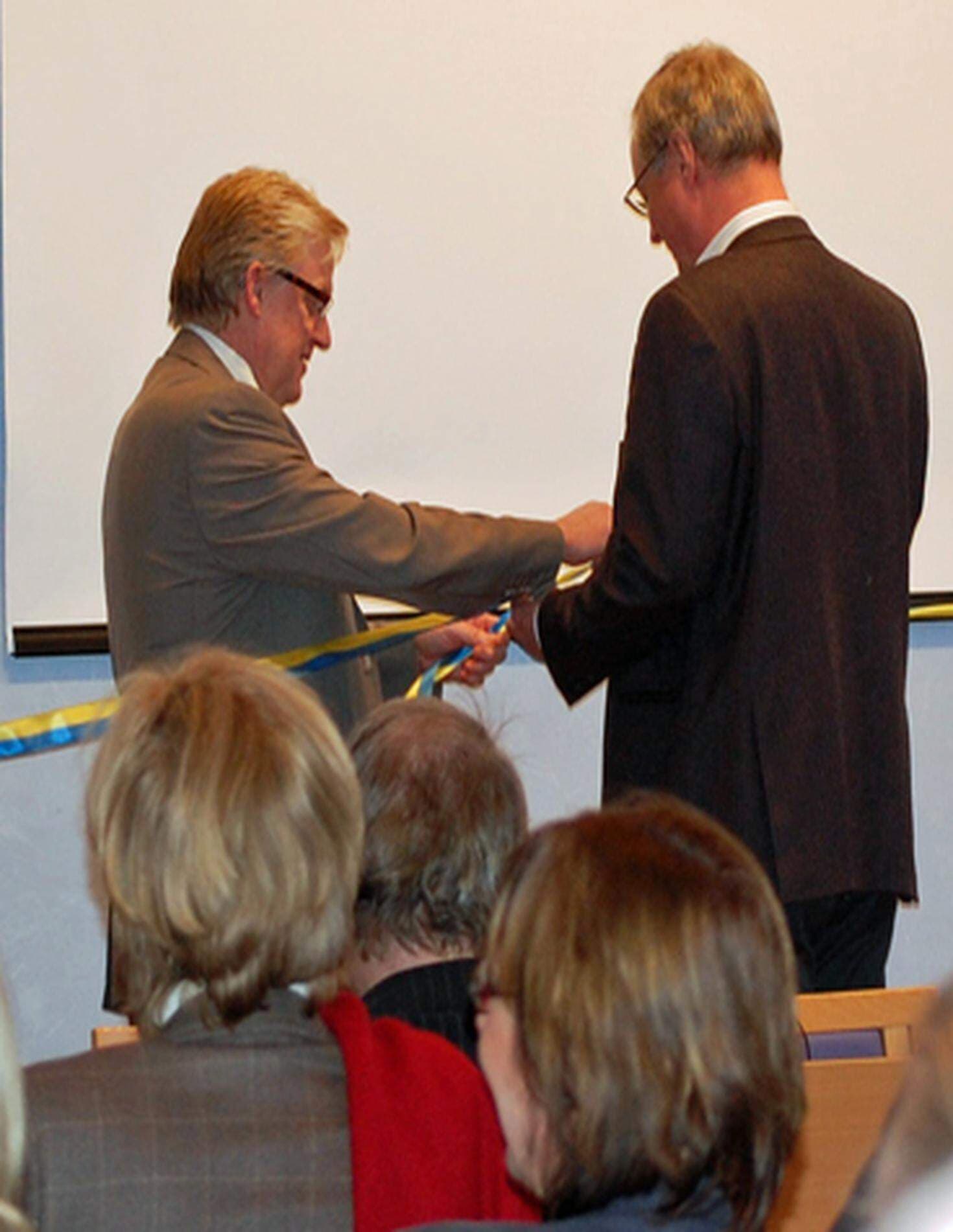 Tommy Hellström och Mikael Rosén knyter symboliskt samman det blå-gula bandet och inviger därmed det "nya" Näringslivets Hus i Falun.