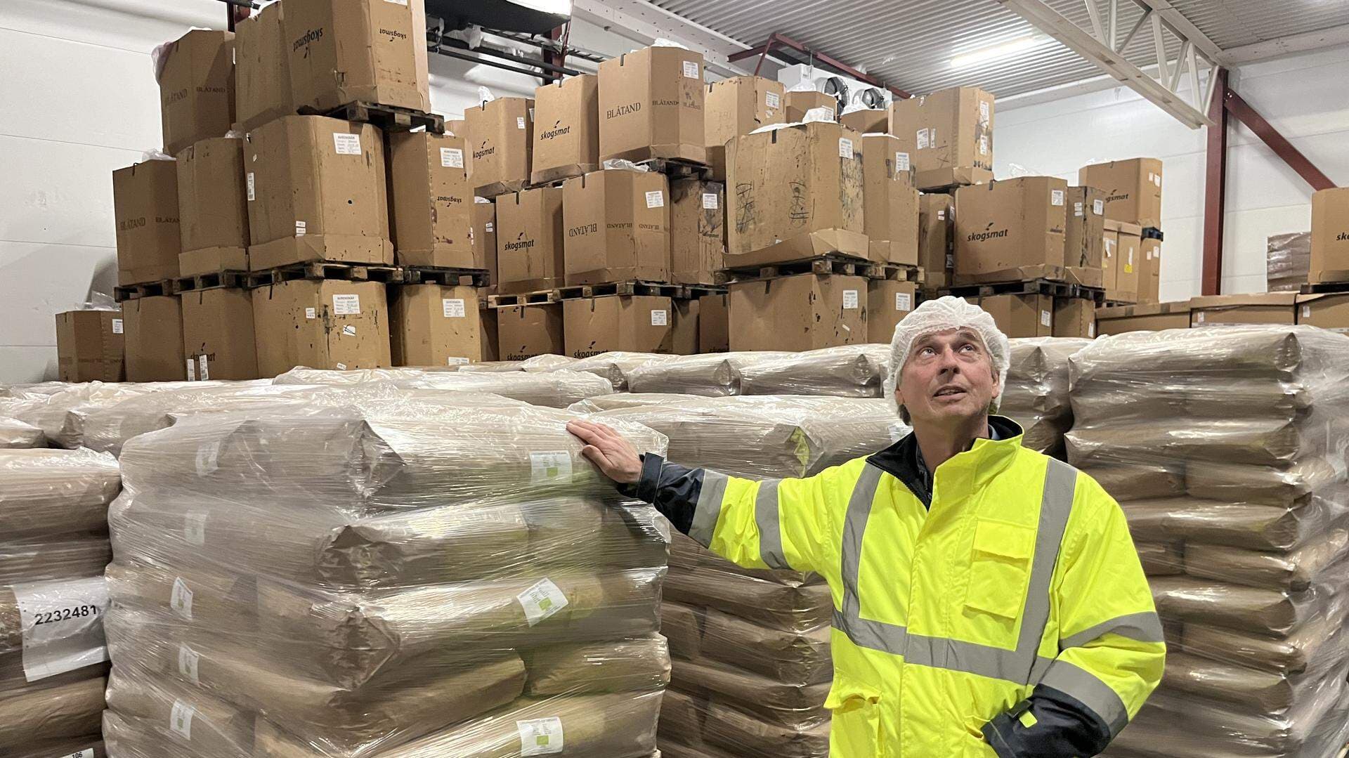 Ulf Hagner står bredvid lastpallar med bärsäckar.