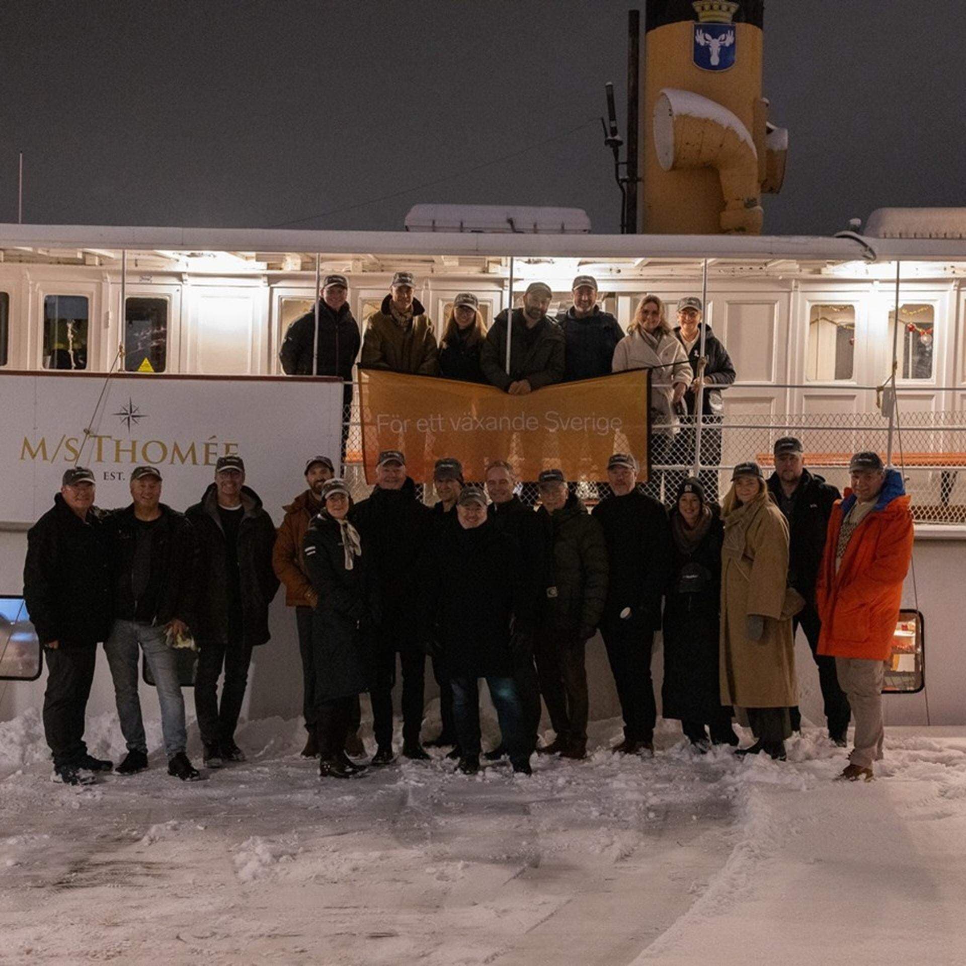 Deltagarna uppställda framför båten MS Thomée