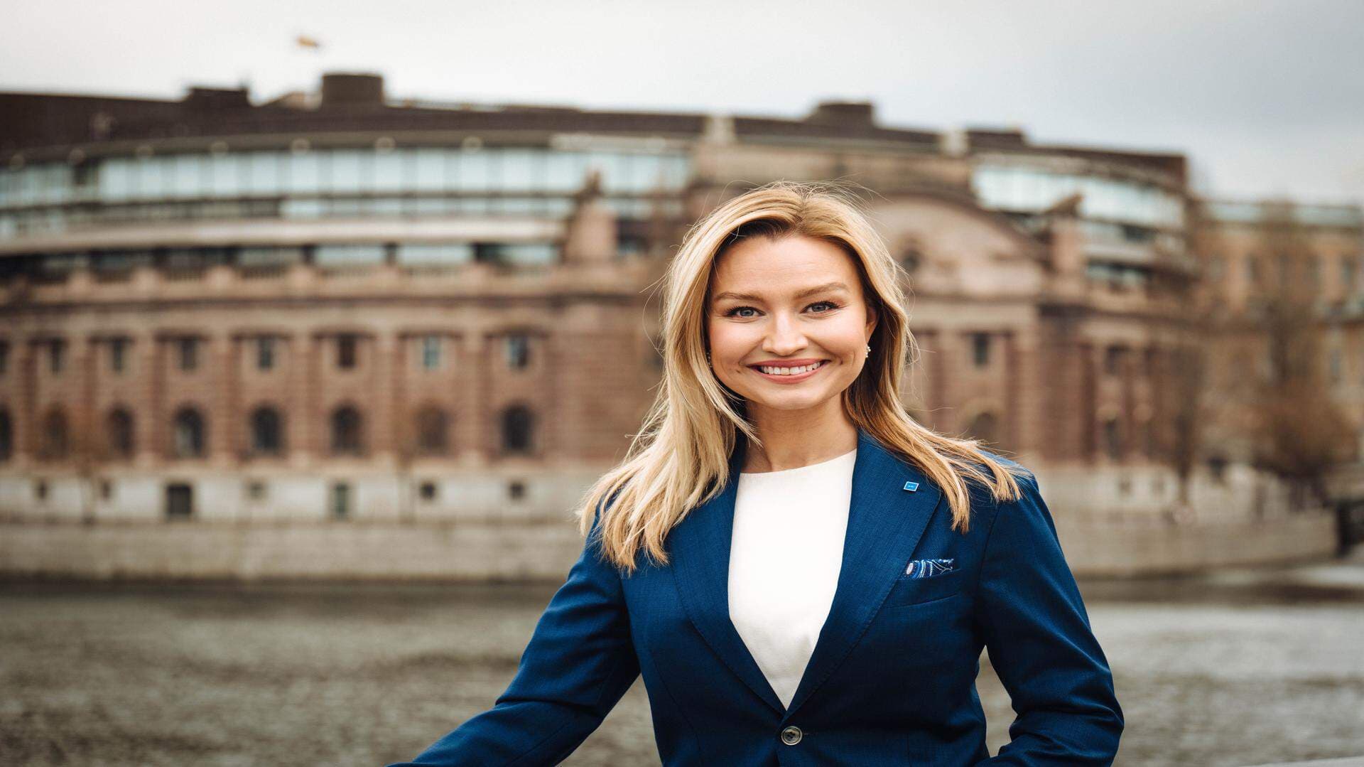 Foto på Ebba Busch framför Riksdagen