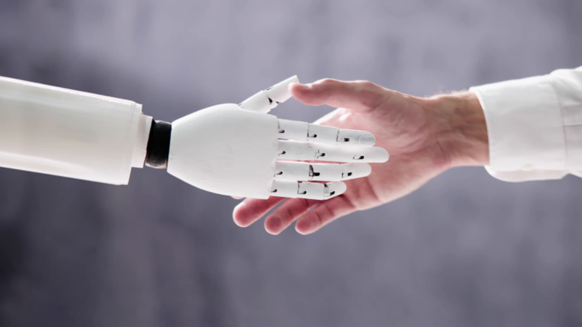 En robothand skakar hand med en människa