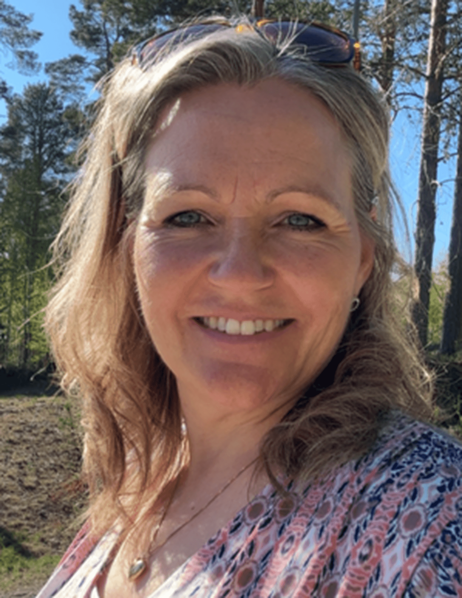 Lisa Sjöö är utomhus och har en blommig tröja.