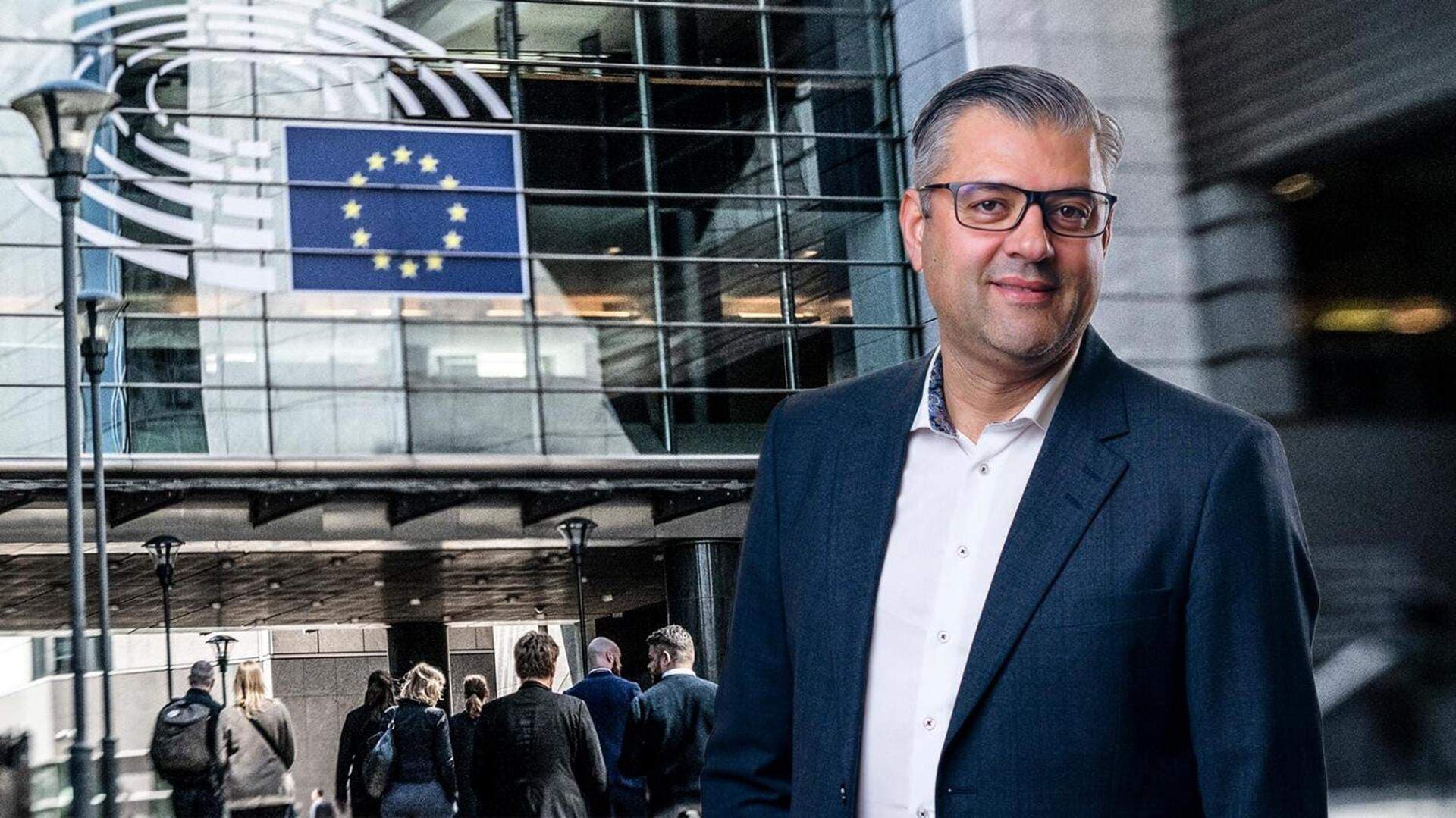 Wadih El-Achkar framför EU-flagga och byggnad