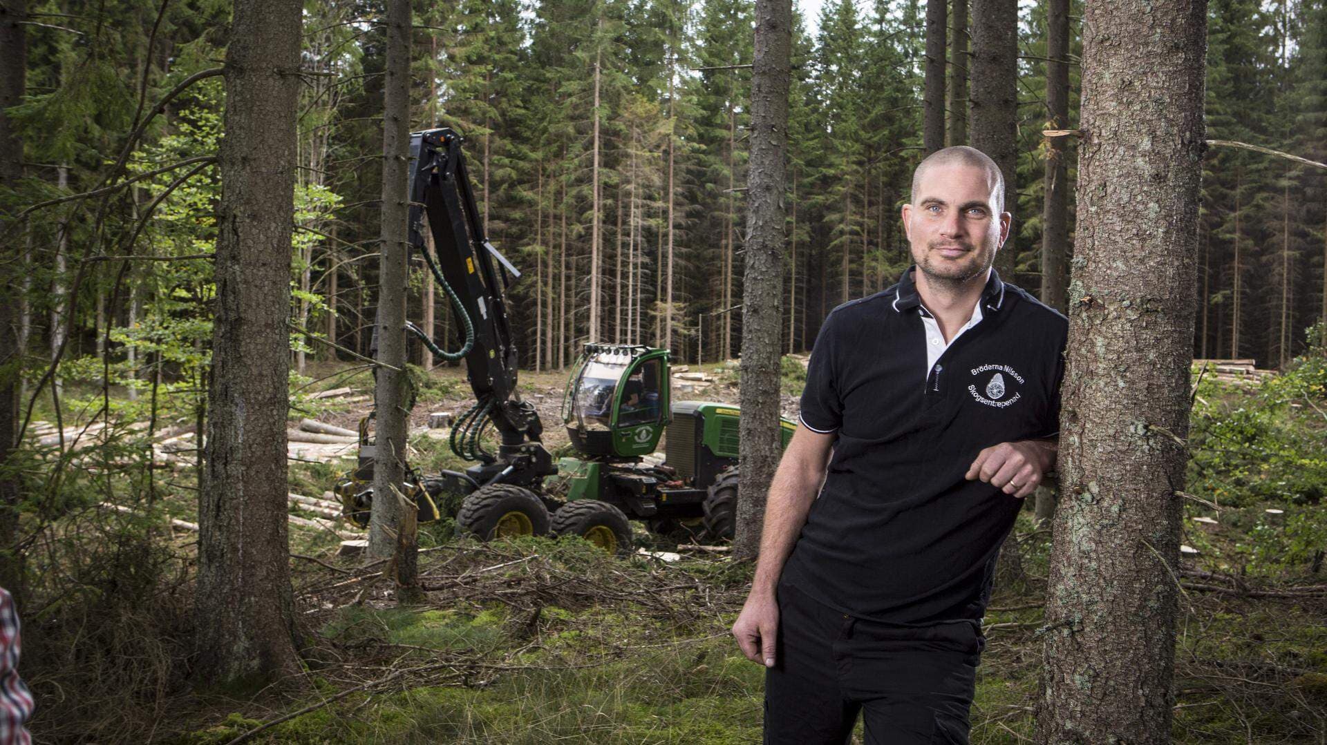 Håkan Nilsson lutar sig mot ett träd i en skog