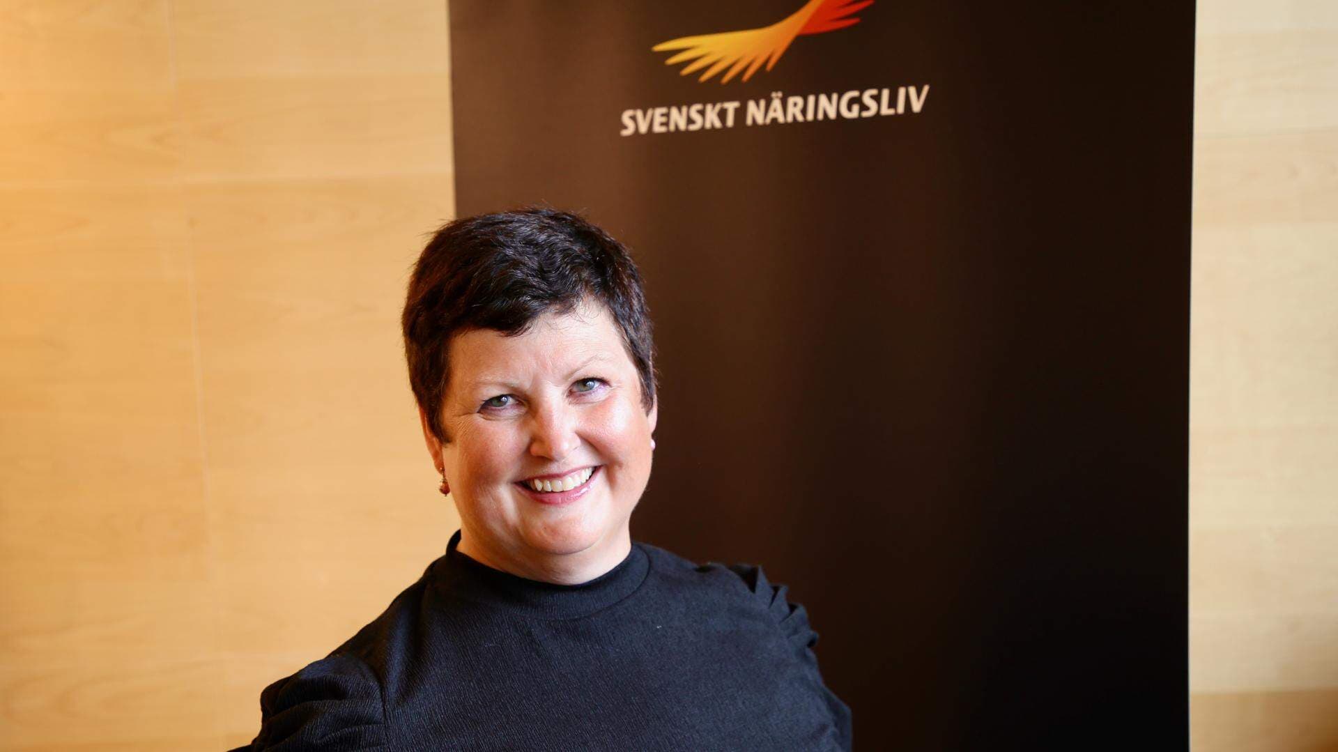 Christina Wainikka står framför en roll-up med Svenskt Näringslivs logotyp.