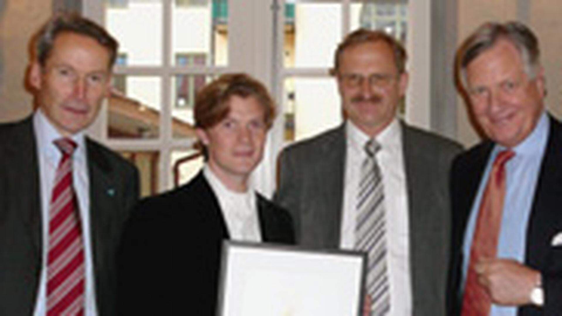 Fyra herrar poserar framför kameran.