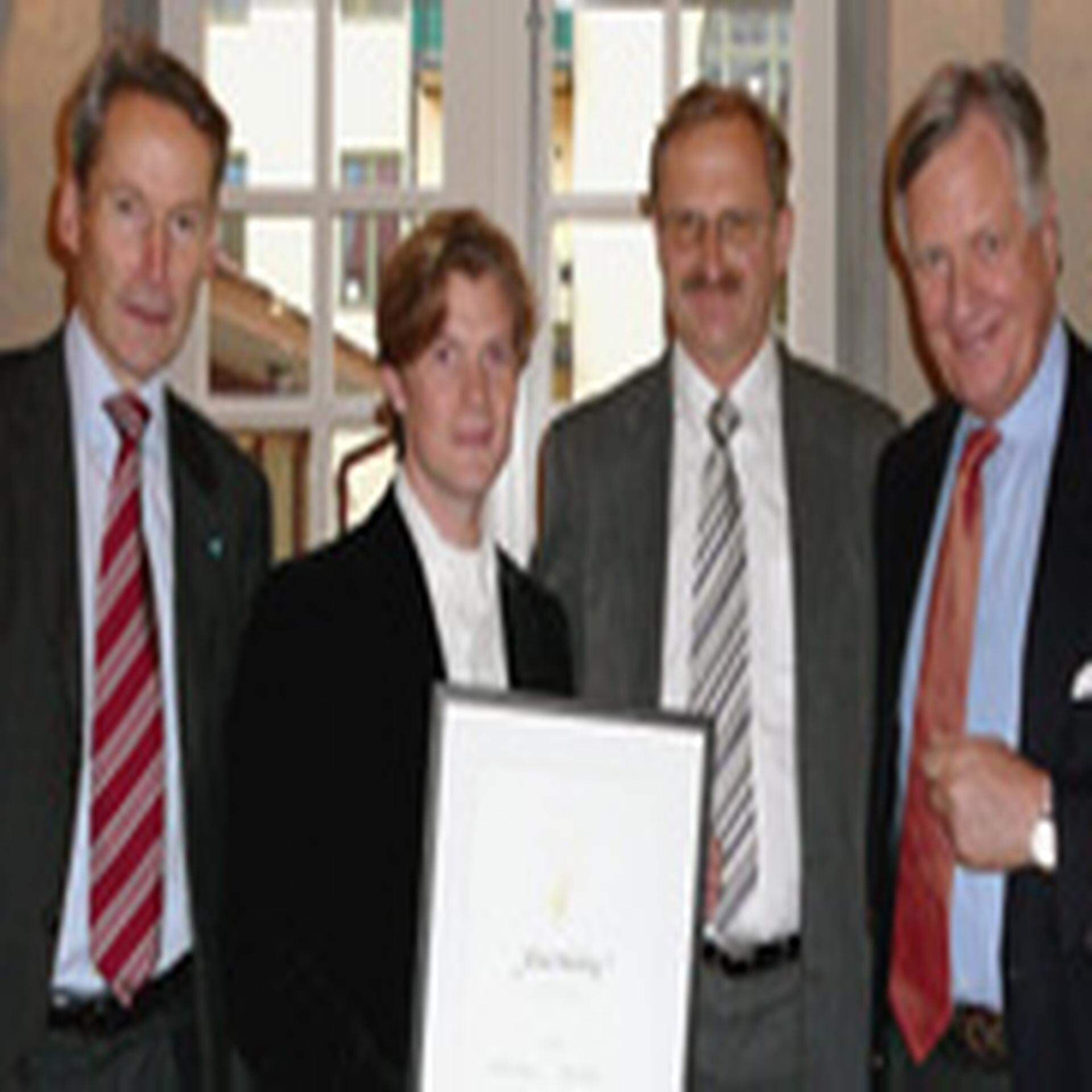 Fyra herrar poserar framför kameran.