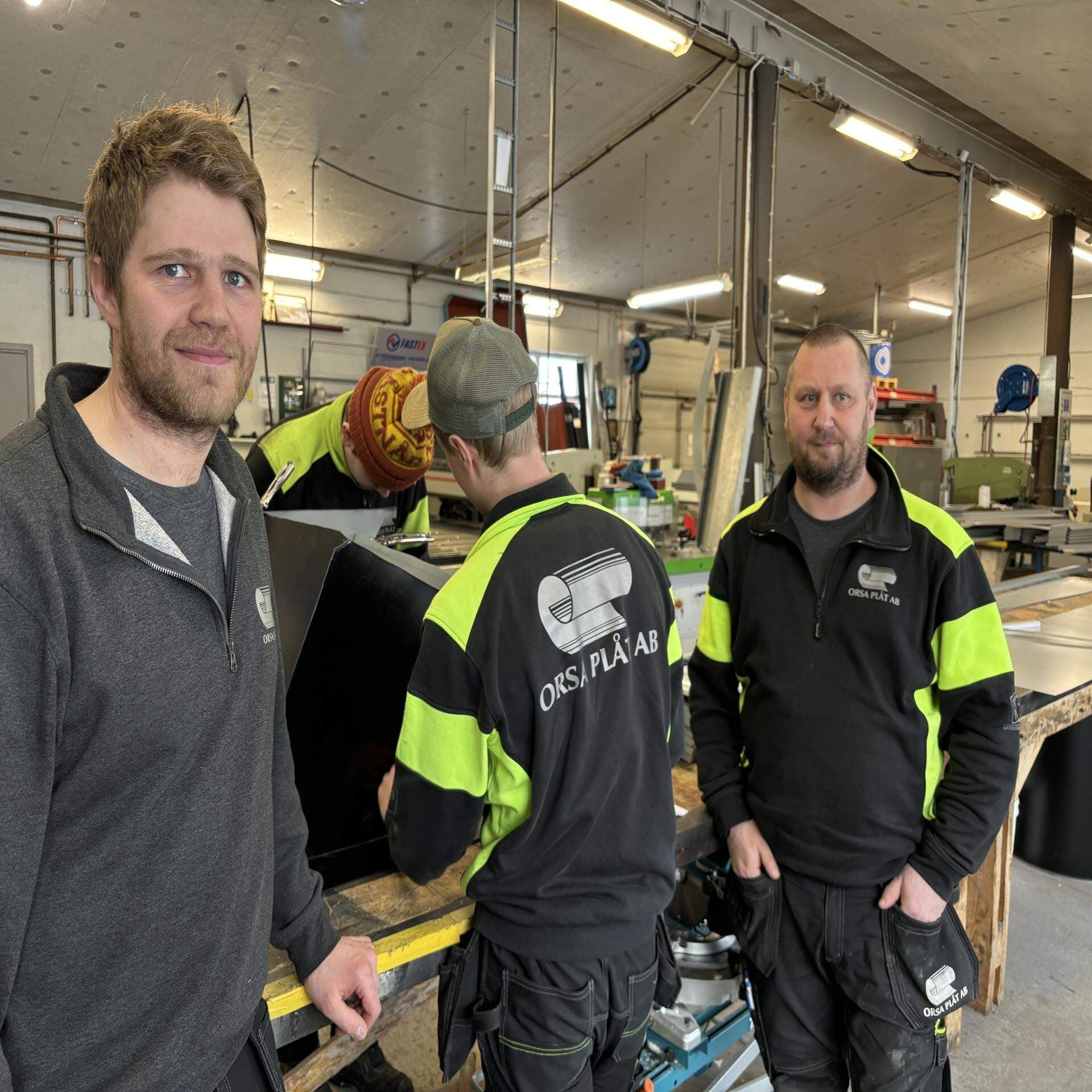 Tre män i en verkstad