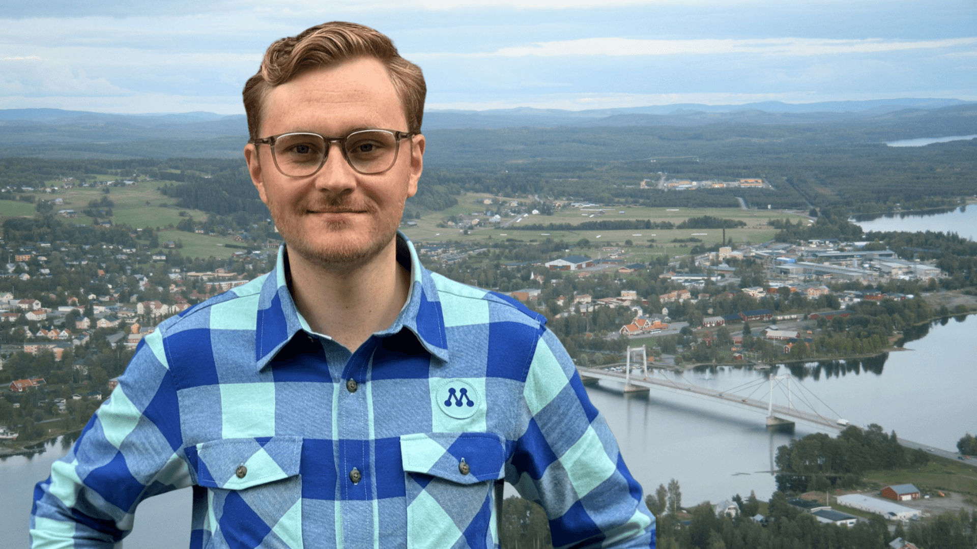 Simon Högberg framför ett flygfoto över Strömsund.