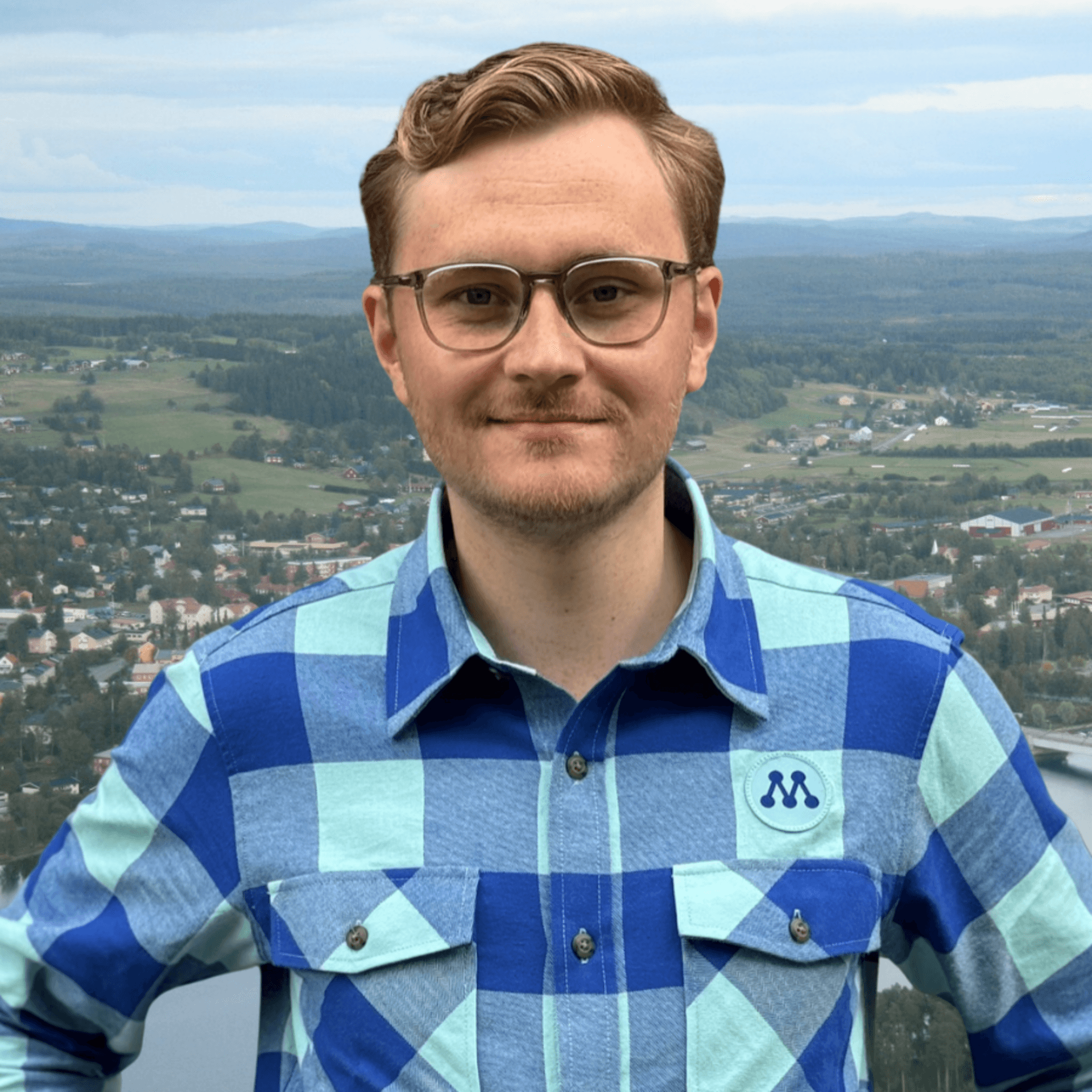 Simon Högberg framför ett flygfoto över Strömsund.