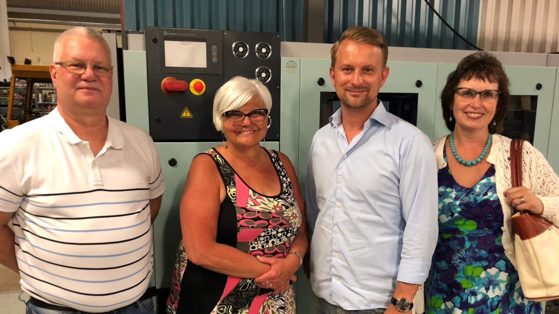 Politiker på företagsbesök står framför en maskin