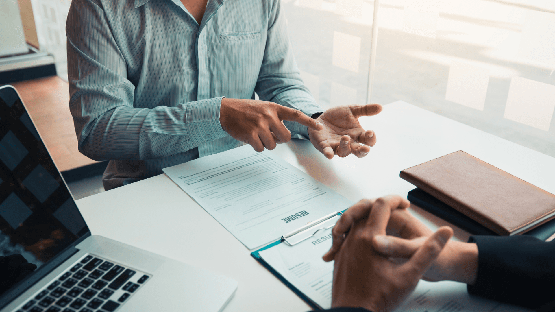 Två personer vid ett skrivbord med laptop och dokument