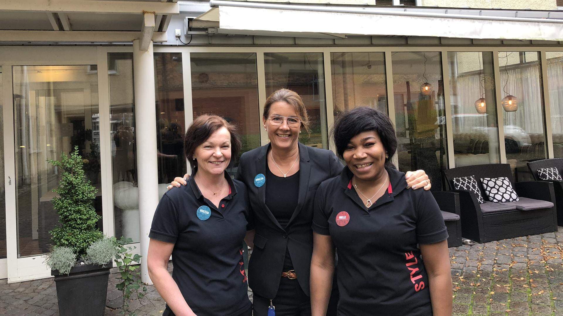 tre personer utanför ett hotell