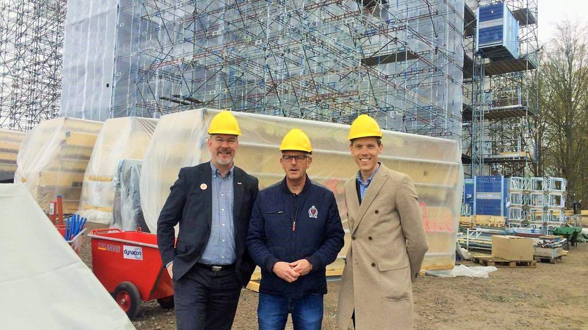 tre personer vid ett bygge