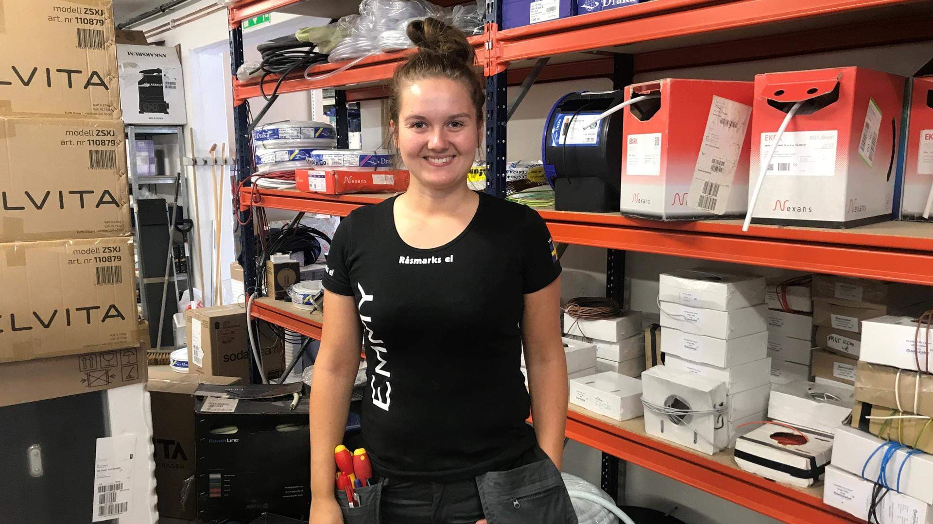 Tjej bland förråd med el kablar