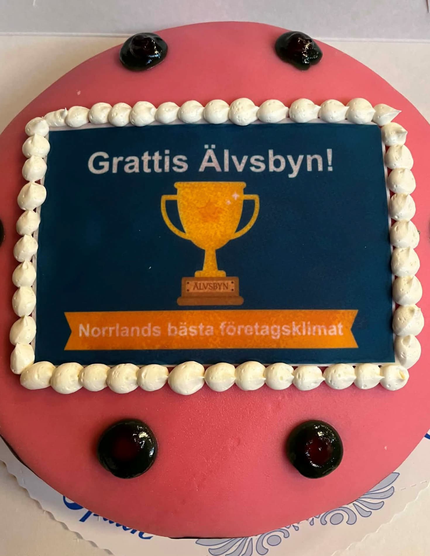Tårta med texten ”Grattis Älvsbyn Norrlands bästa företagsklimat” och en pokal.