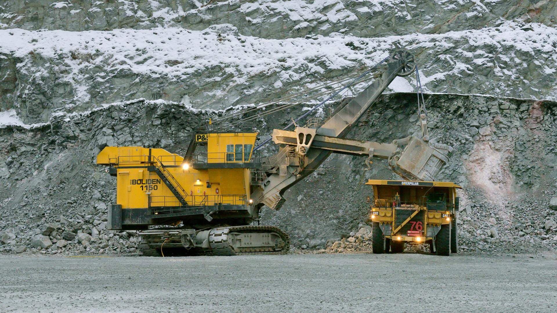 Maskin lastar malm på en dumper.