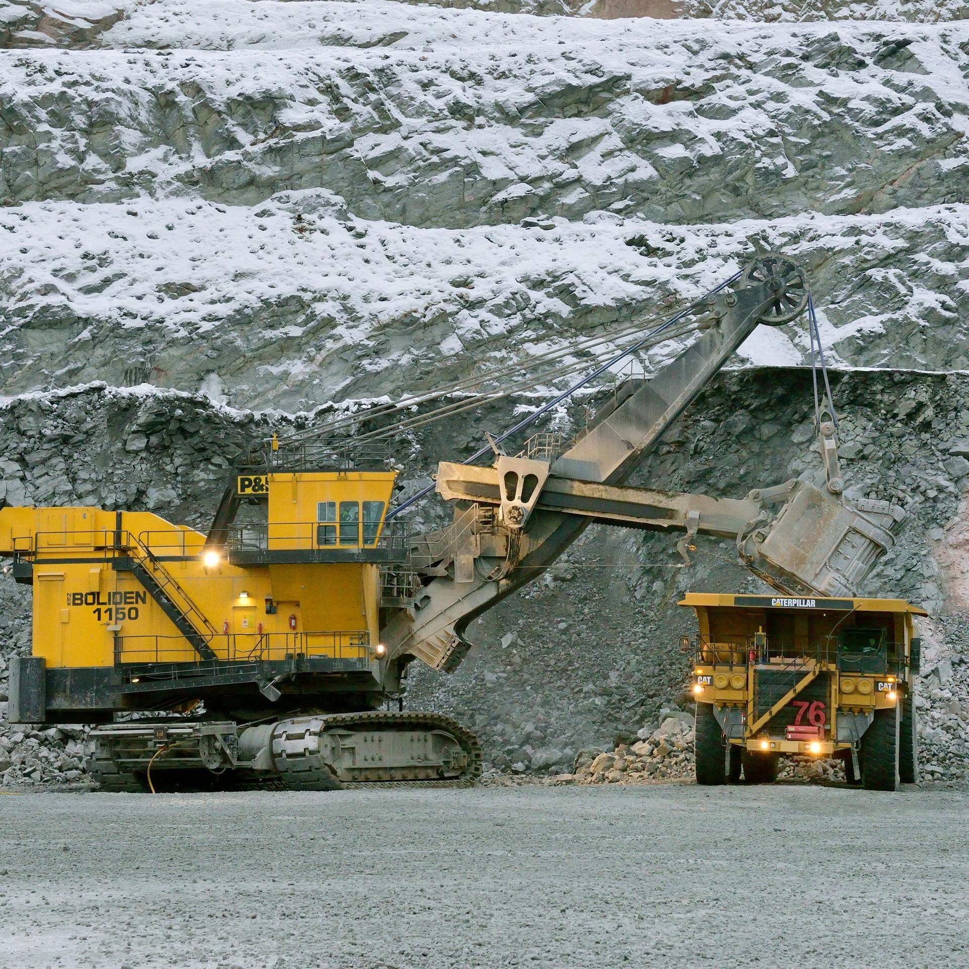 Maskin lastar malm på en dumper.