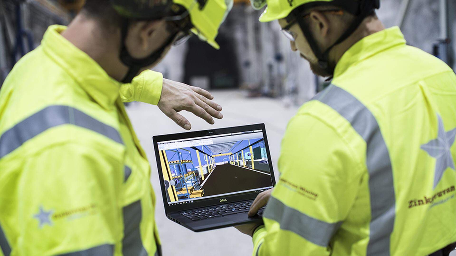 Två gruvarbetare från Zinkgruvan Mining som tittar på en laptop.