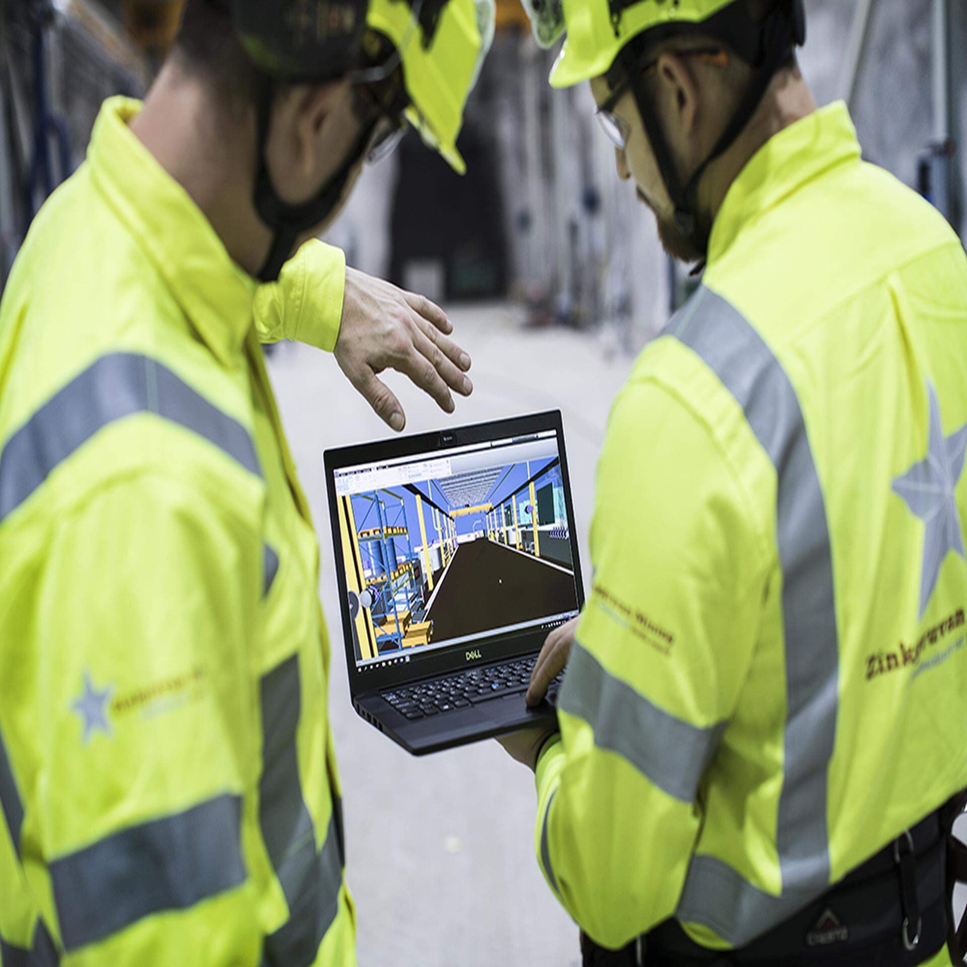 Två gruvarbetare från Zinkgruvan Mining som tittar på en laptop.