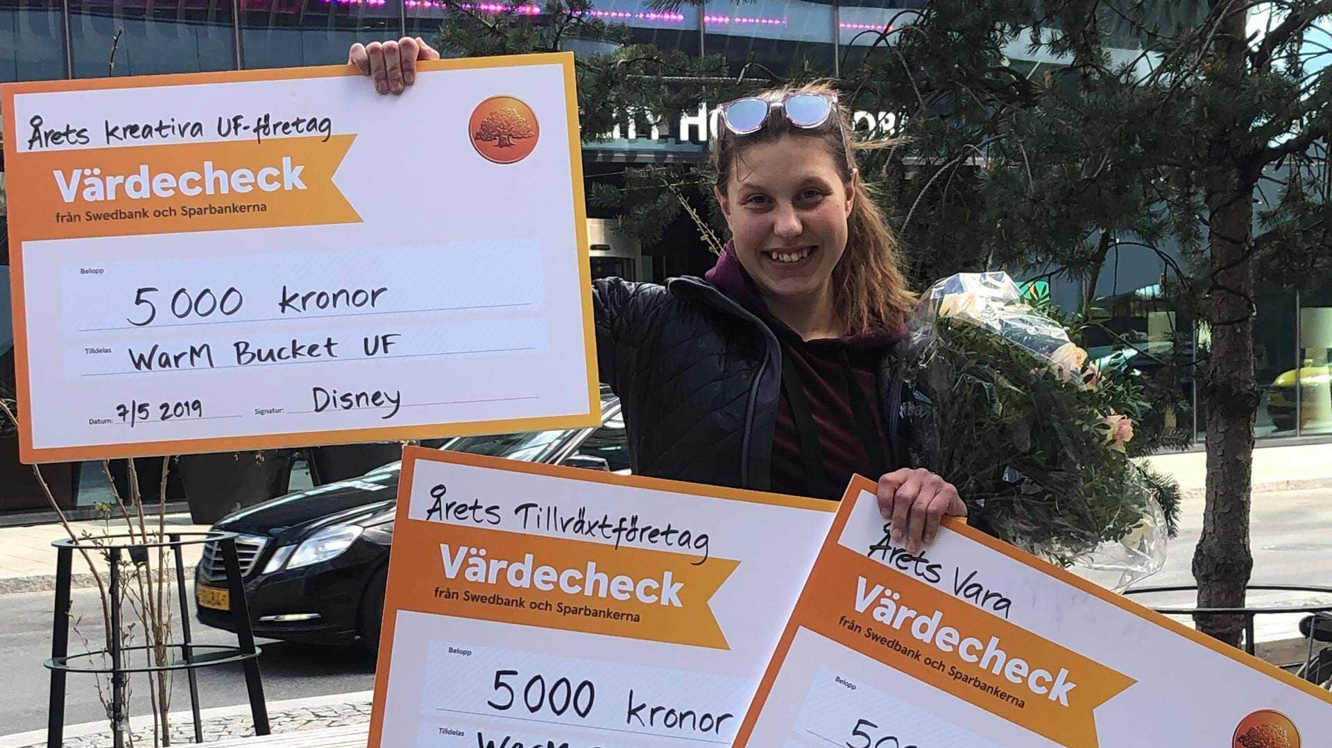 Wilma Martinsson som håller upp sina tre vinst-checkar