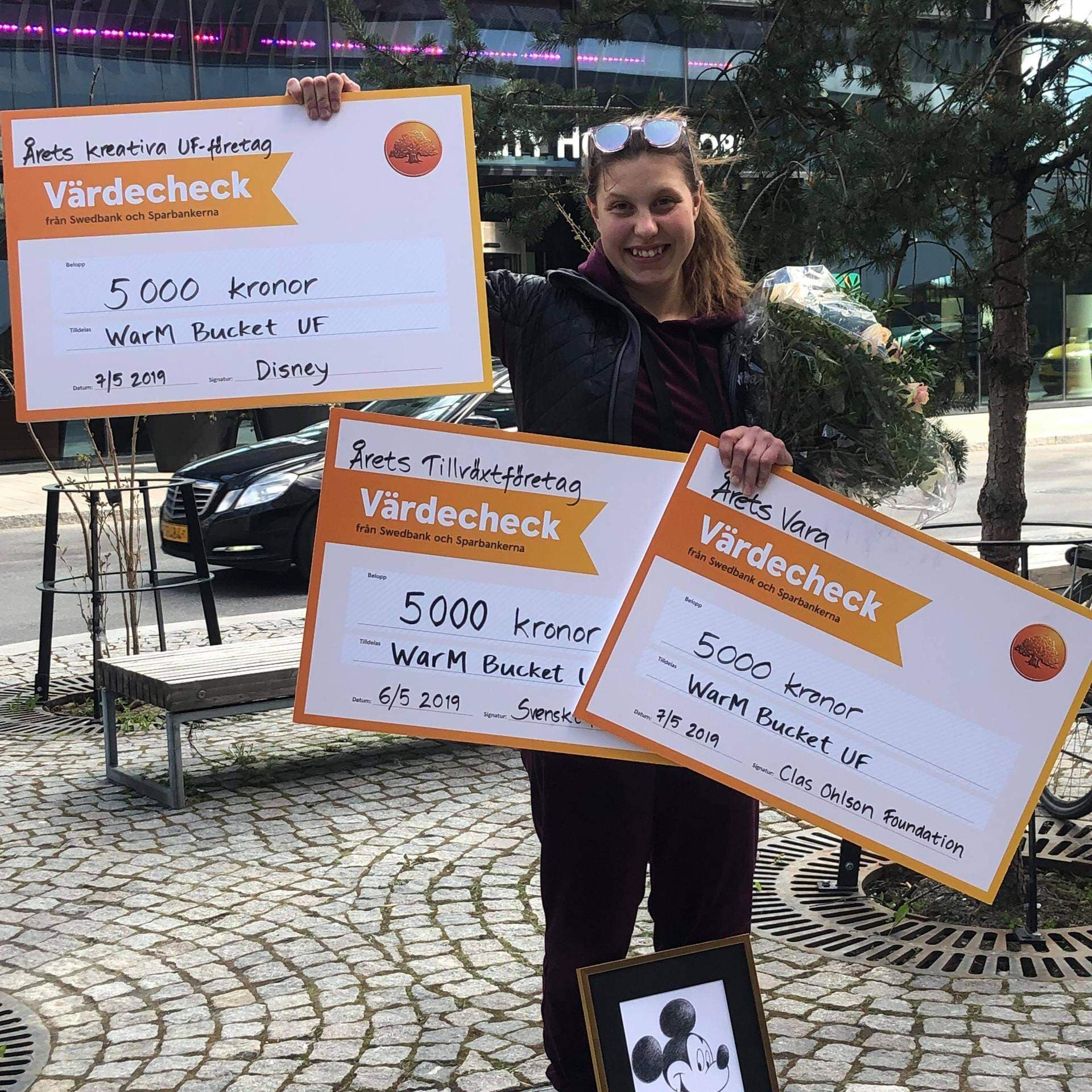 Wilma Martinsson som håller upp sina tre vinst-checkar