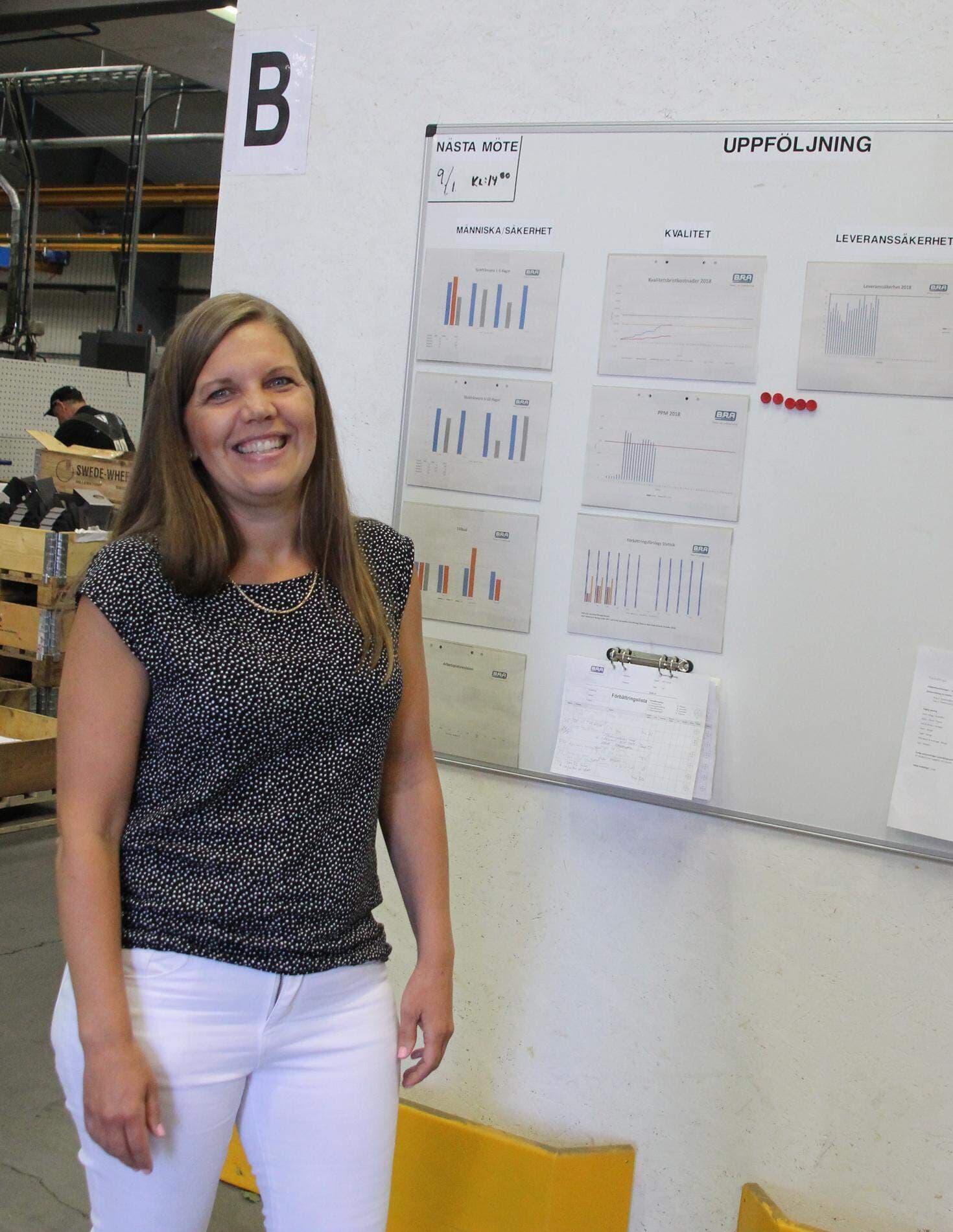 Theresa Boman framför tavlan som visar hur företaget går och var det finns förbättringspotential.