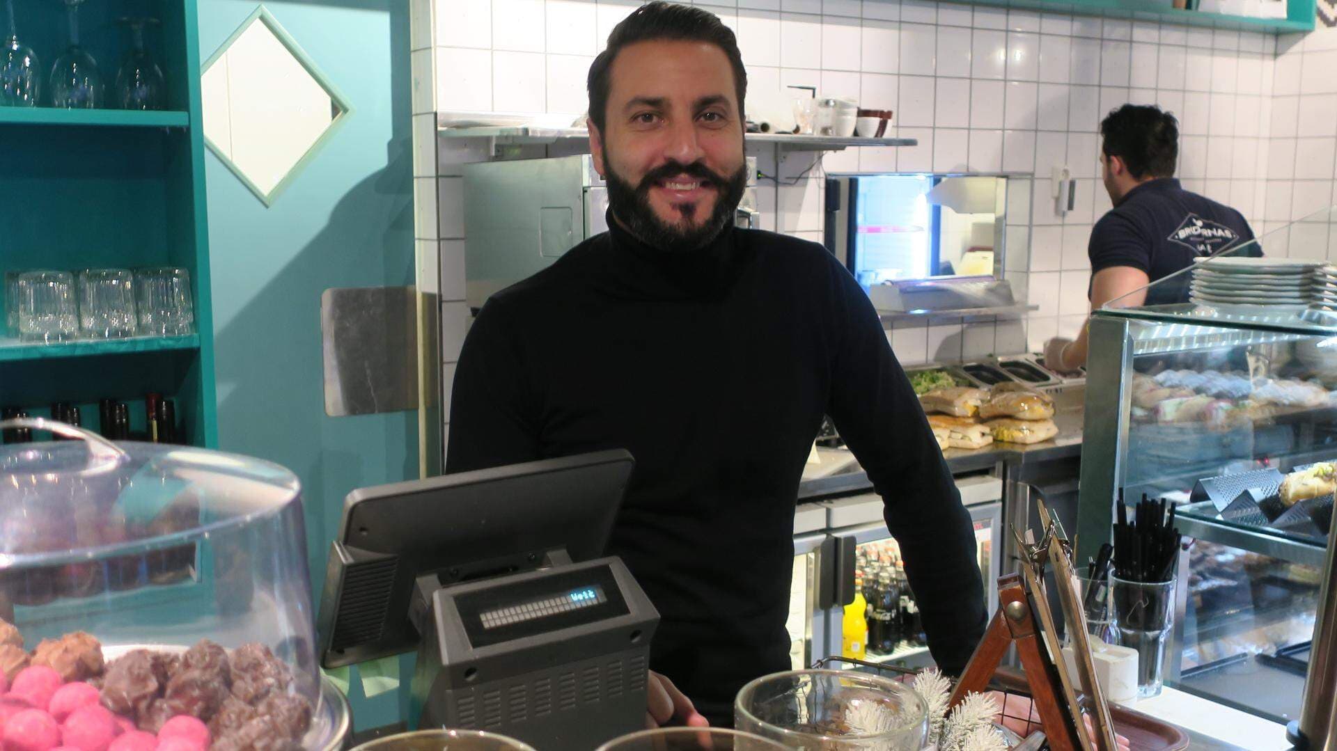 Robert Togan bakom kassadisken på Brödernas Kafé
