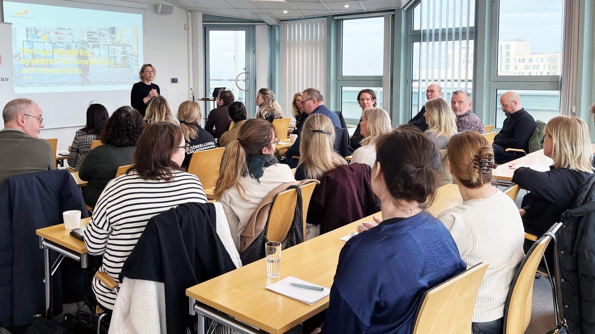 Carina Lindfelt i ett konferensrum med deltagare