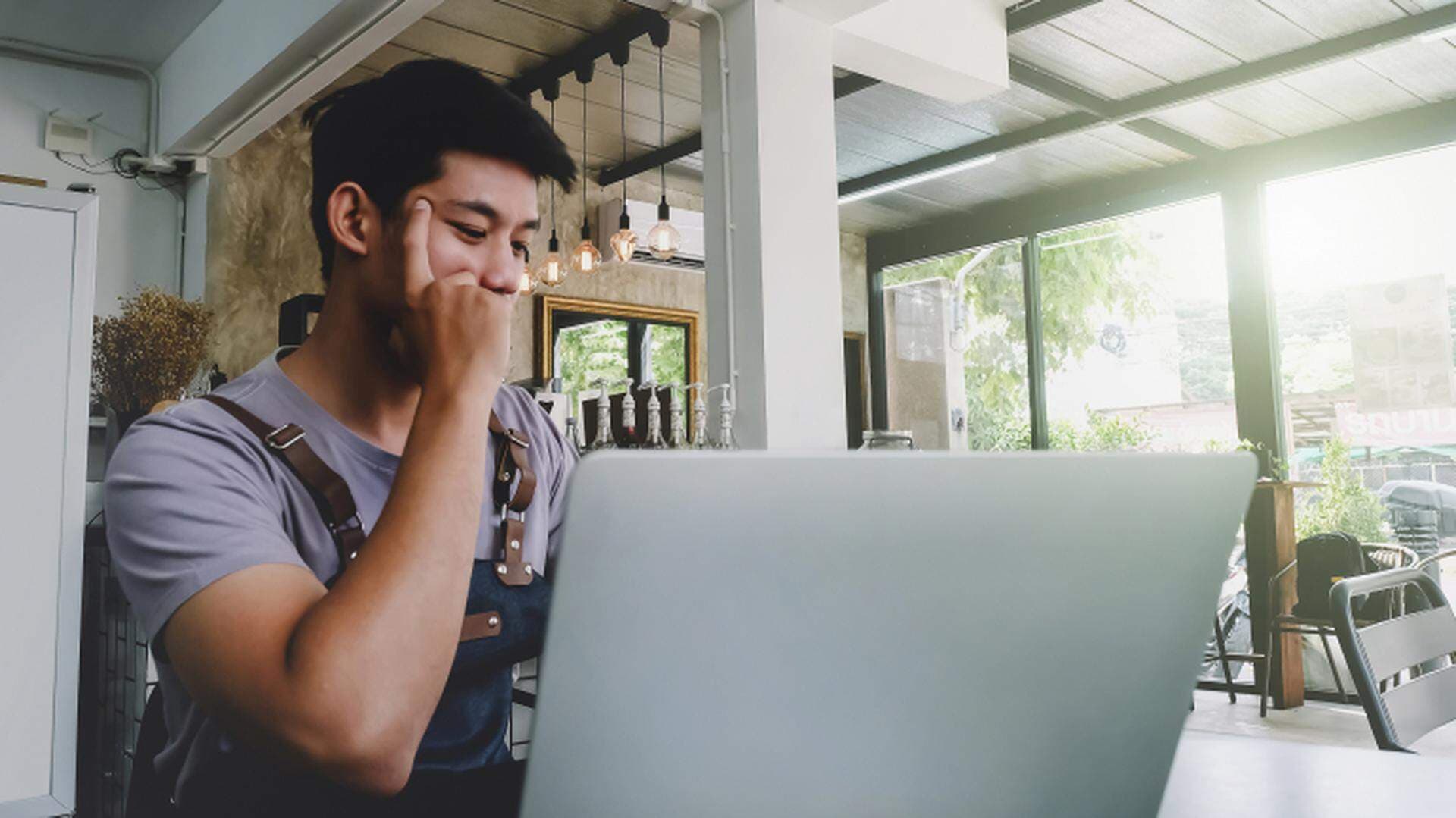 En man vid cafebord vid en laptop
