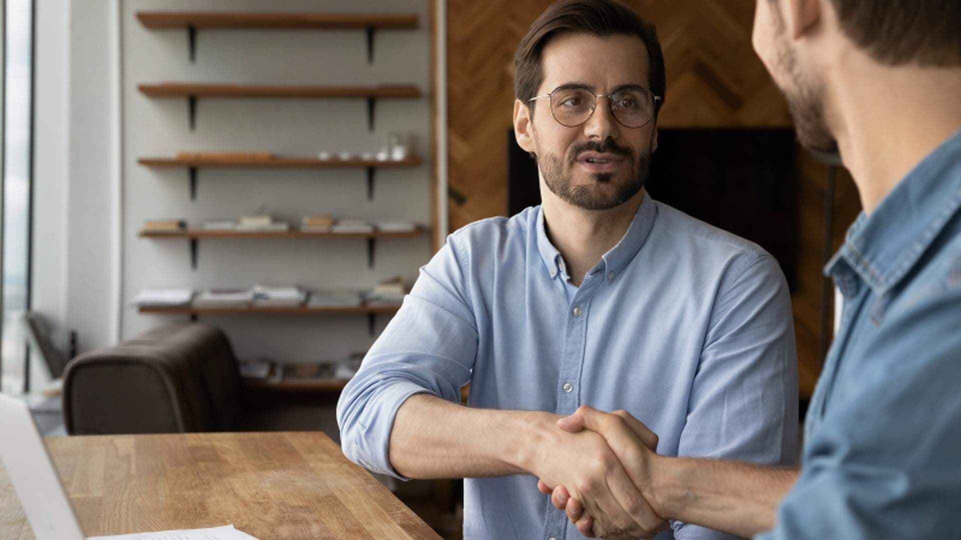 två personer i en intervju som tar i hand