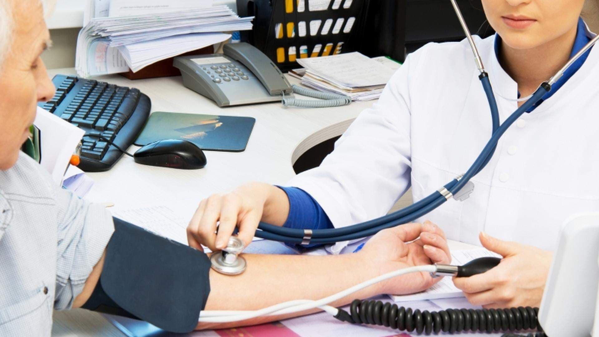 läkare kollar blodtryck på patient