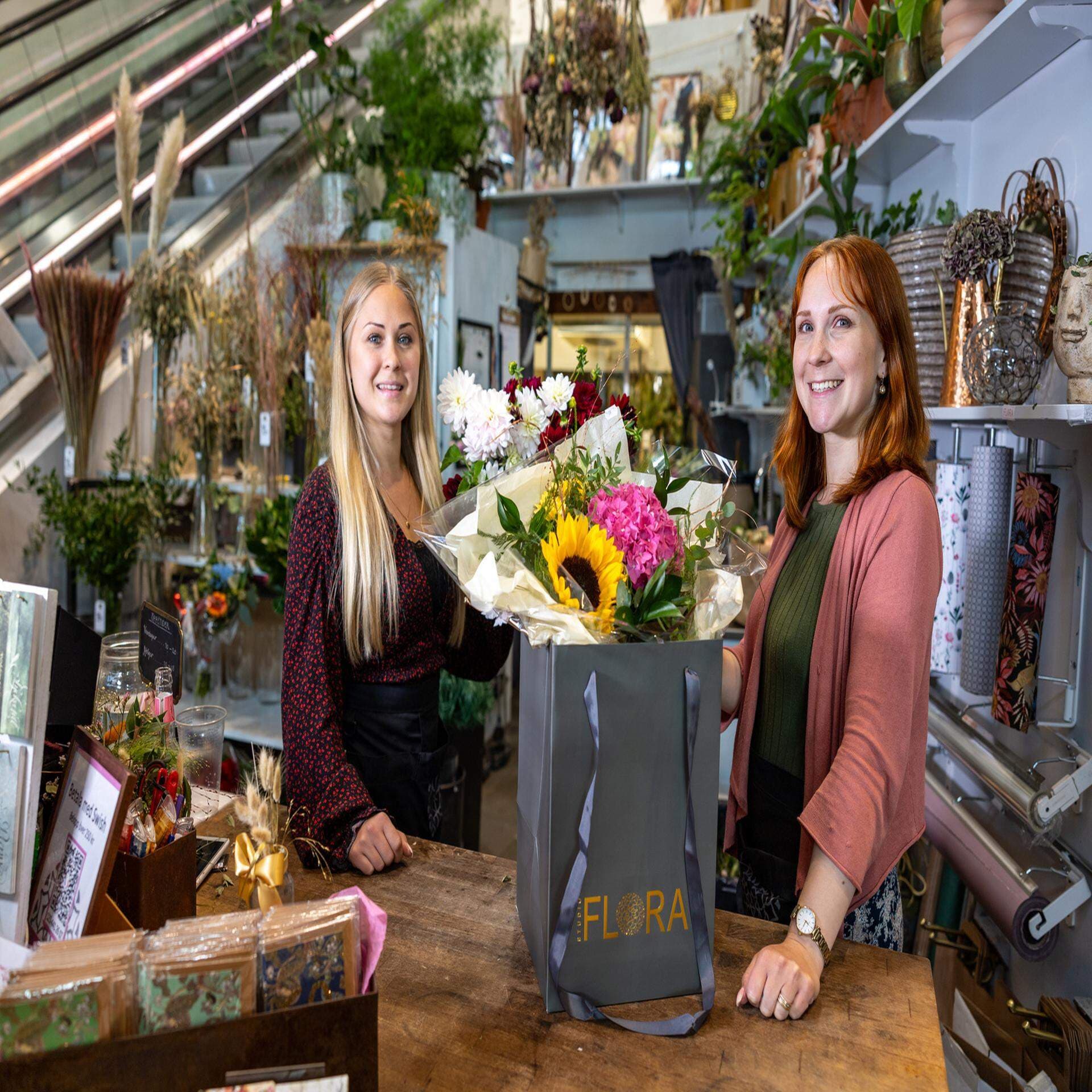Bilden föreställer två kvinnor i en blomaffär