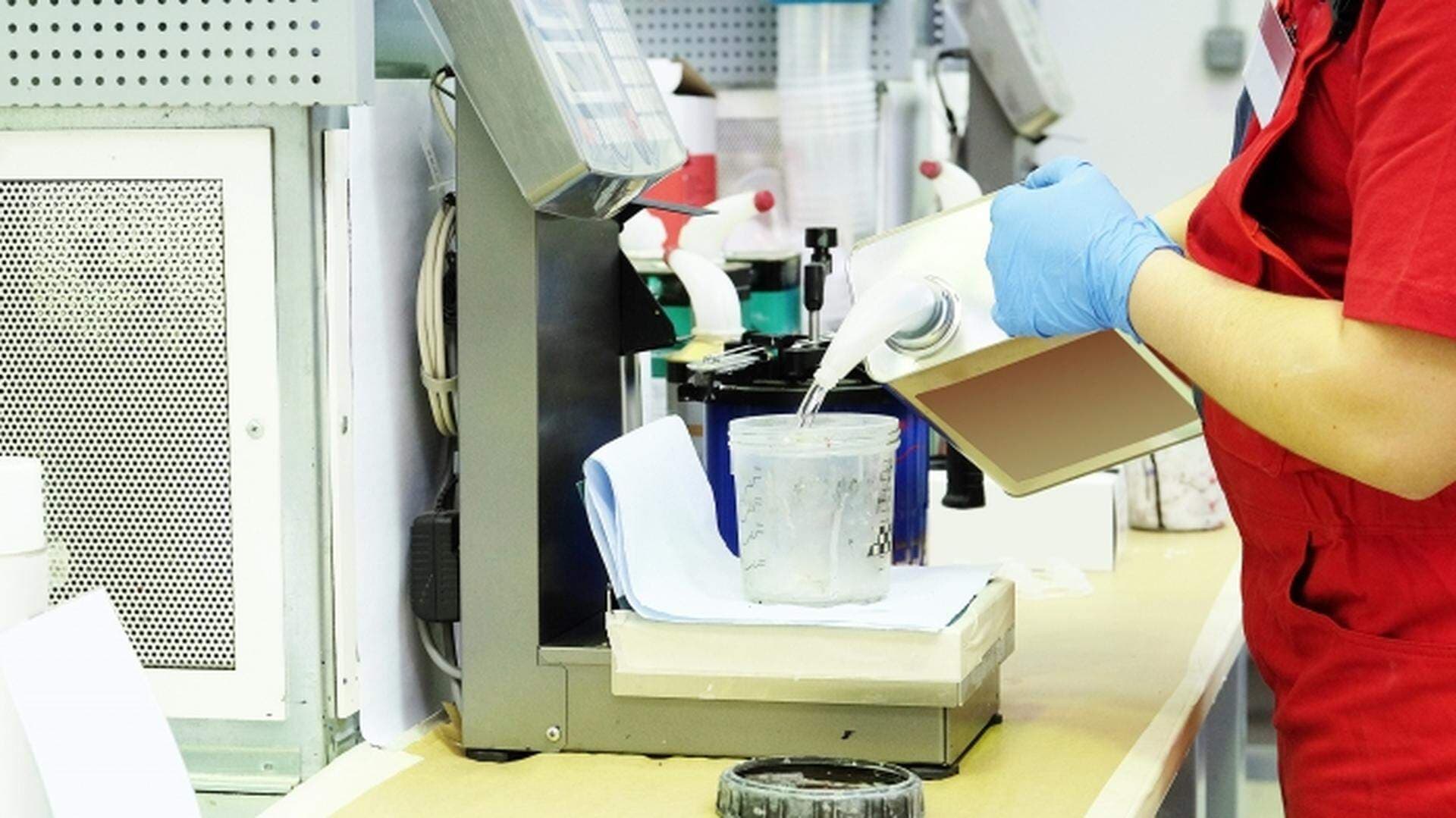 någon som häller i någon vätska i en burk