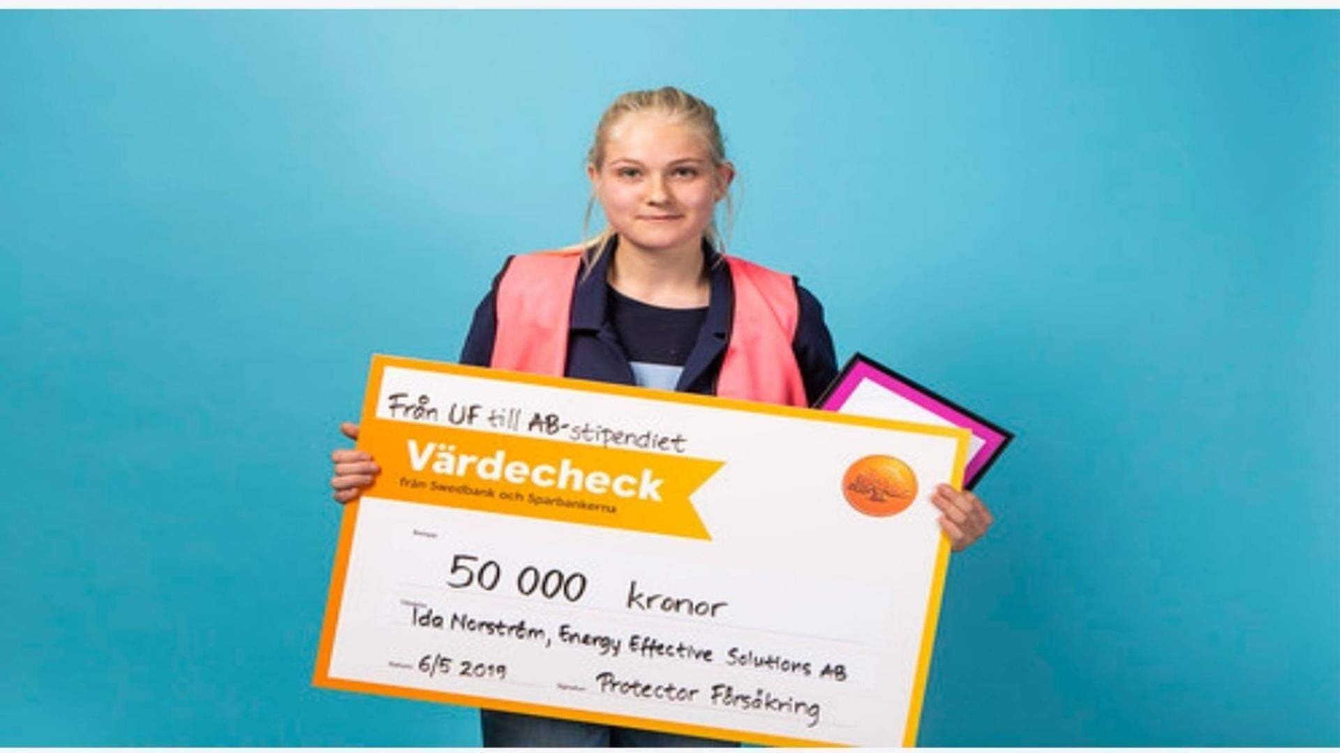Ida Norström håller i sin värdechecheck för "Från UF till AB-stipentiedt"