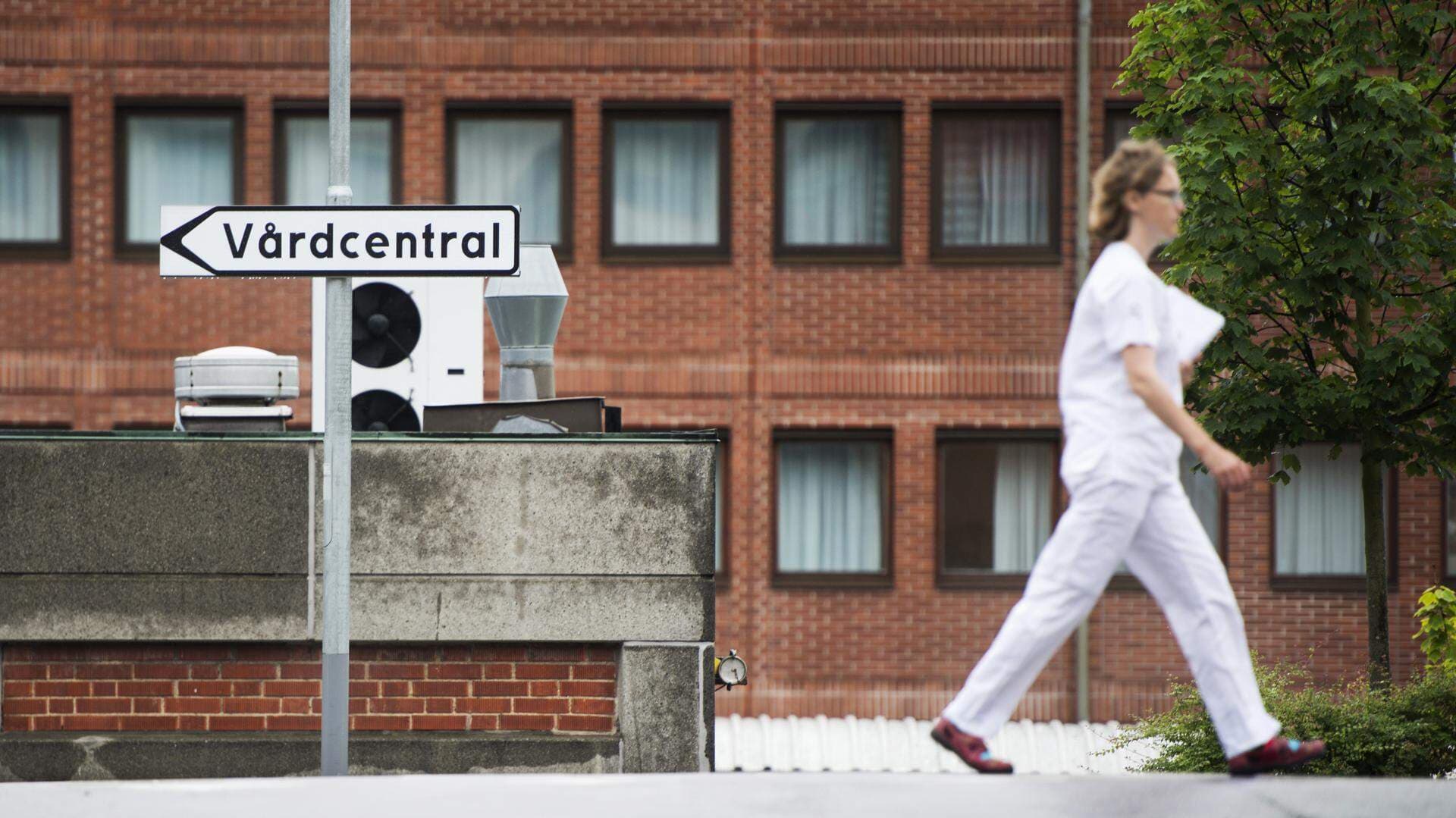 Läkare som går motsatt håll mot vad skylten med texten vårdcentral visar