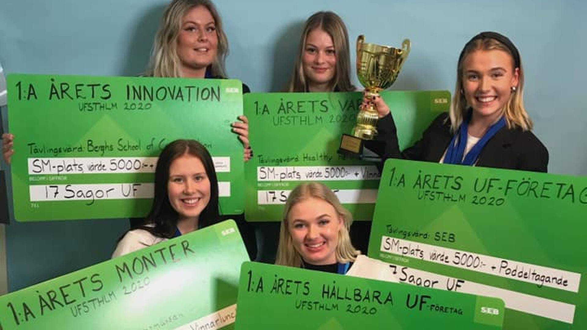 Ida Rönnberg, Betina Pierre, Julia Nordenskjöld, Emma Holmlund och Saga Fjellheim i sin monter på årets UF-mässa håller upp sina vinstcheckar och pokal