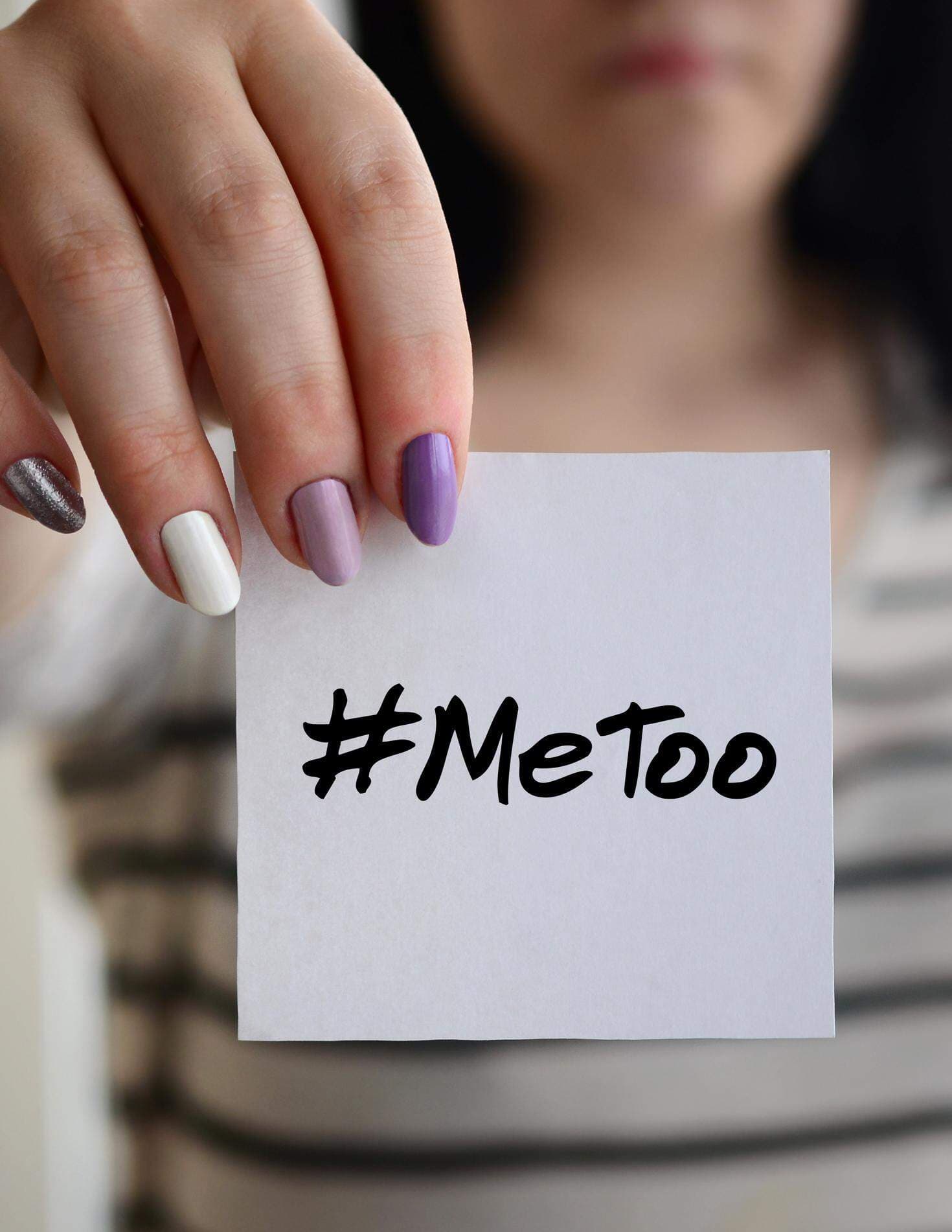 Tjej som håller upp en lapp med texten #MeToo