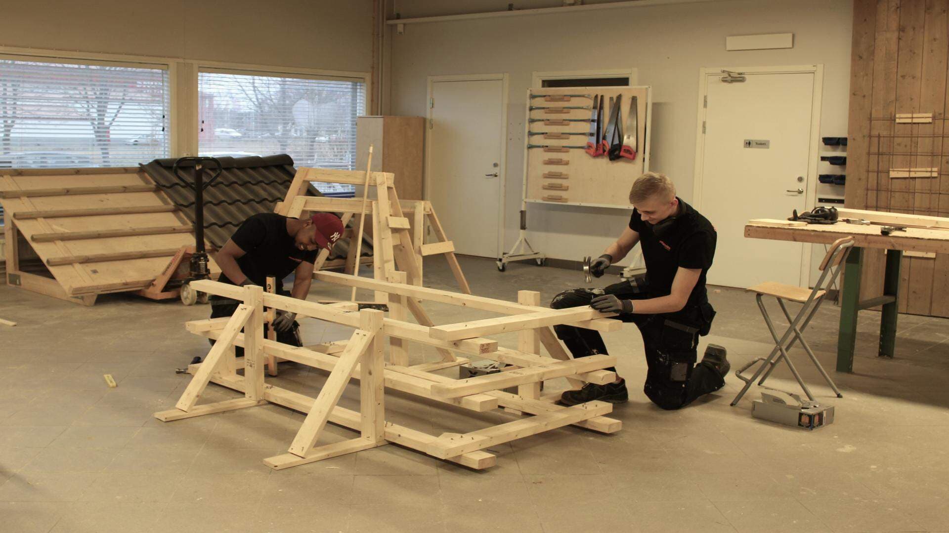 Kader Mahamud och Kevin Carrelind bygger i en lektionssal på Praktiska Gymnasiet