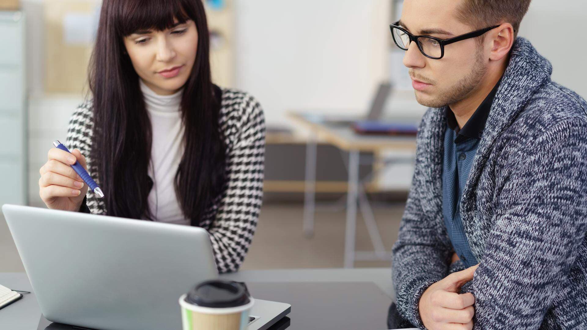 Två personer som tittar in i en laptop