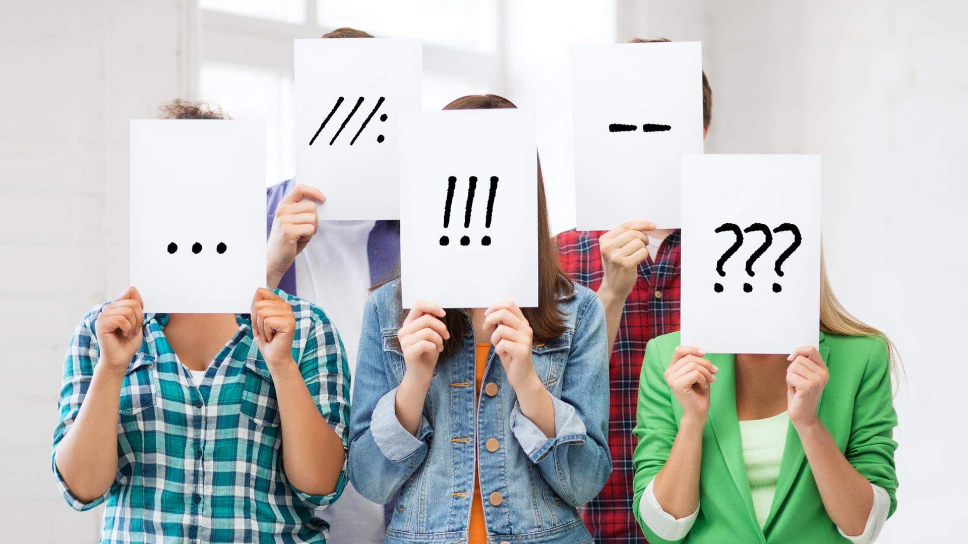 Ungdomar som har pappersark framför ansiktena med olika tecken på.