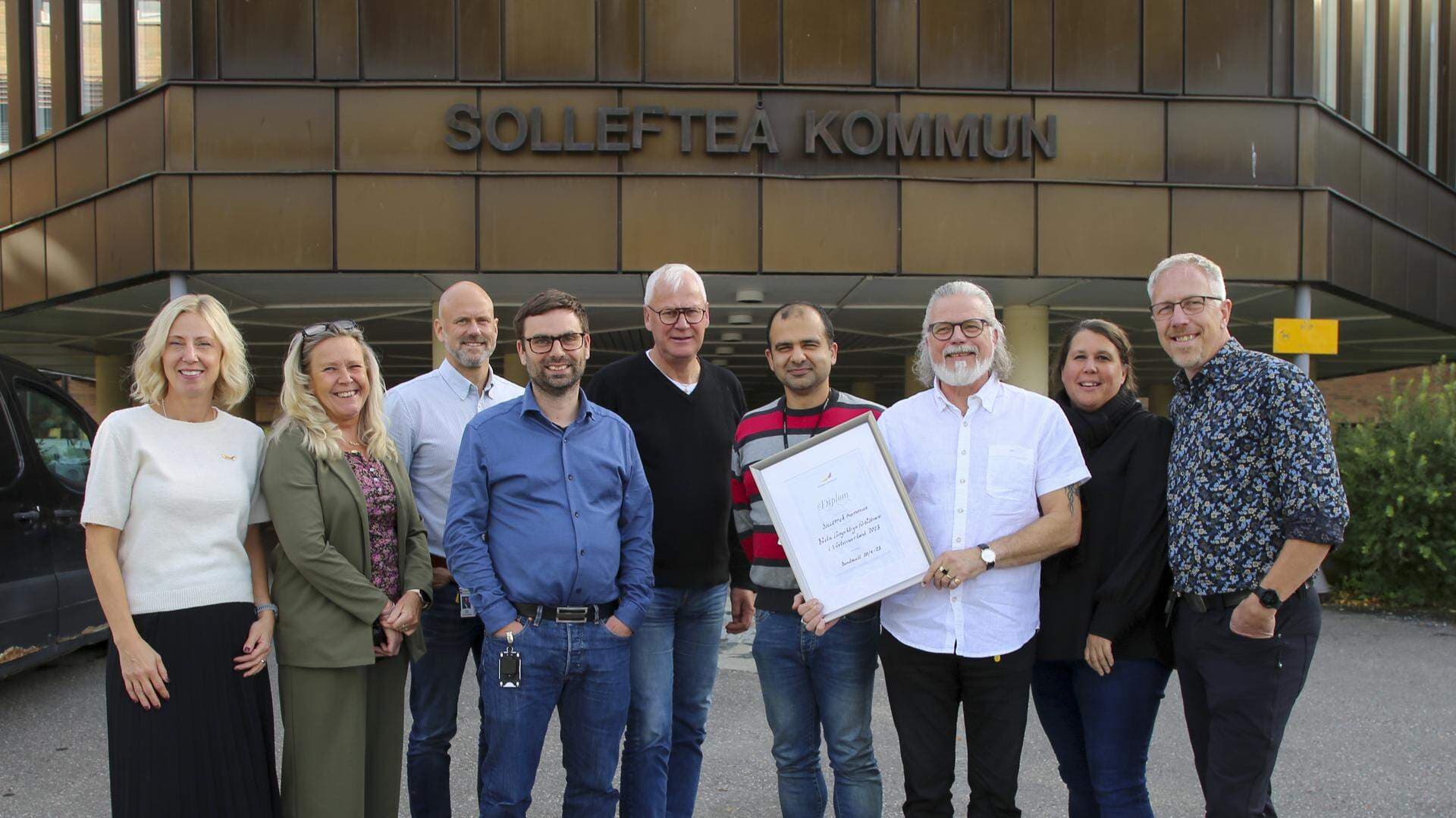 En grupp människor varav en håller i ett diplom.