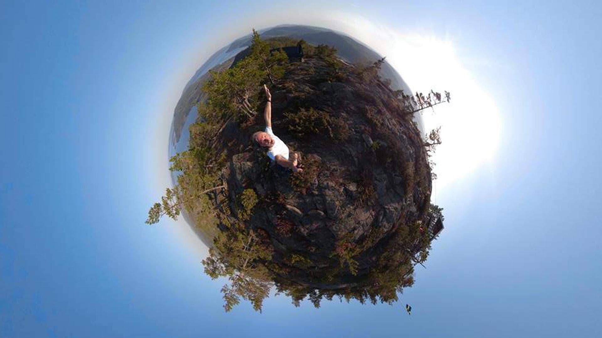 Man som står i en skog på ett jordklot