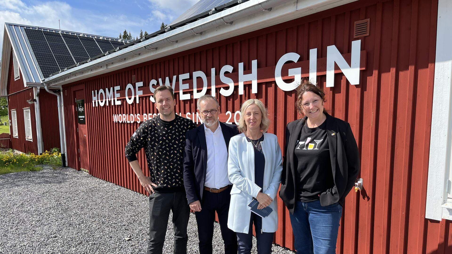 Fyra människor framför en röd byggnad